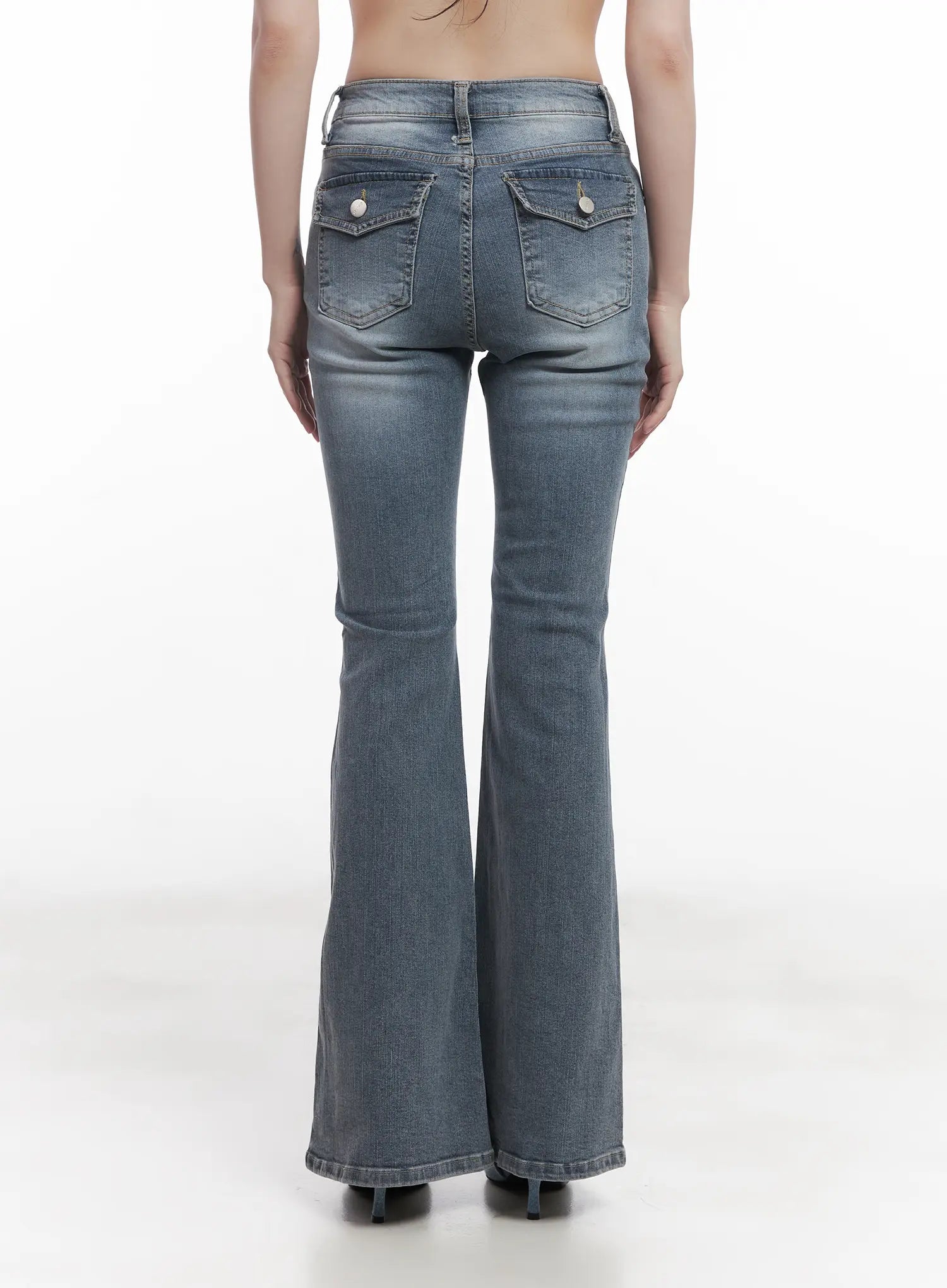 Soyeon Flared Jeans with Hip Pads CU520 in dark gray, back full-length on model, washed slim bootcut silhouette with snap-button back pockets and subtle flare from knee down.