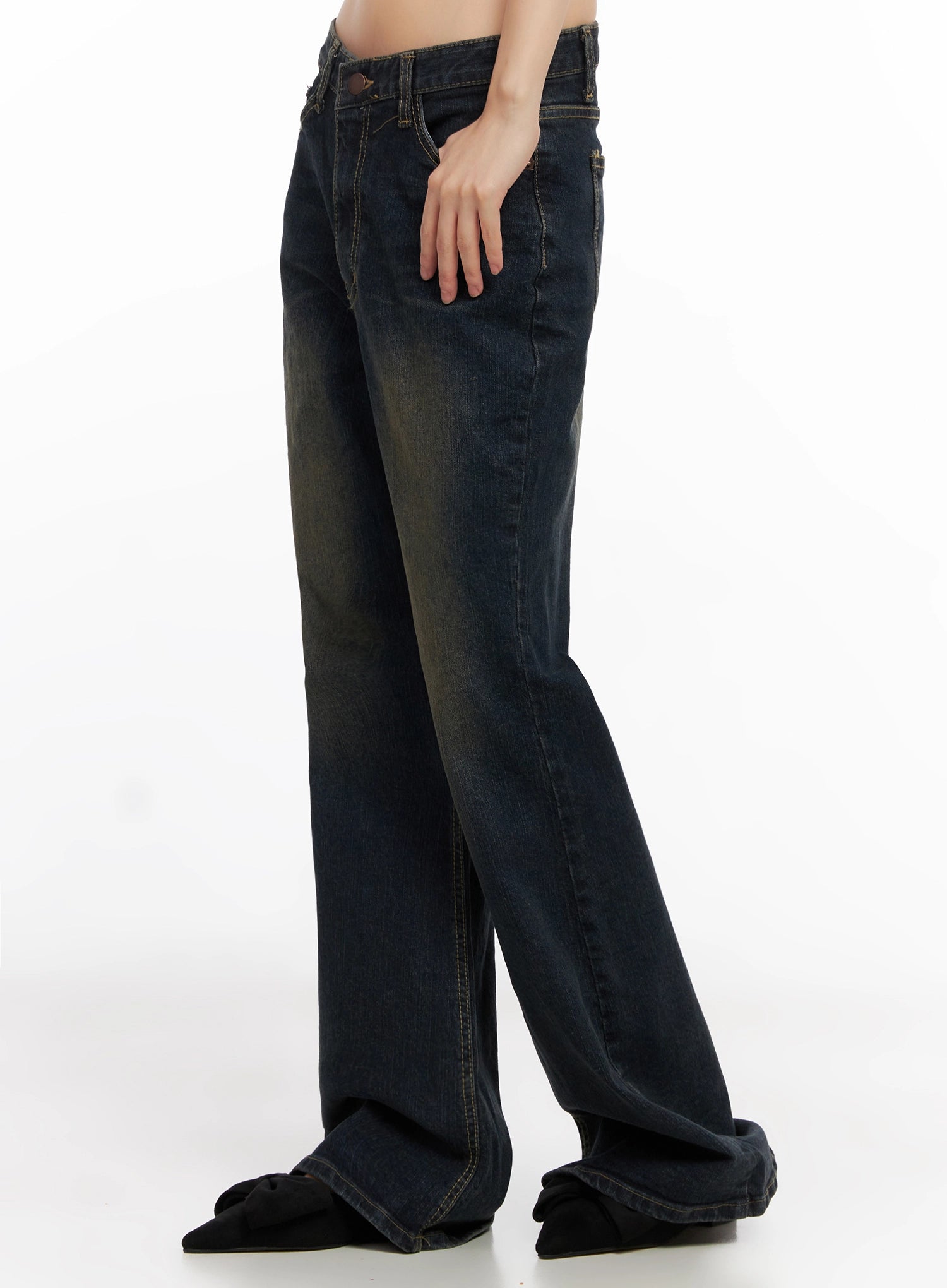 Lyanna Vintage Wash Bootcut Jeans IN503 in dark blue, side-angle view on model, hand in pocket, showing back pocket placement and gradual flare from knee to hem.