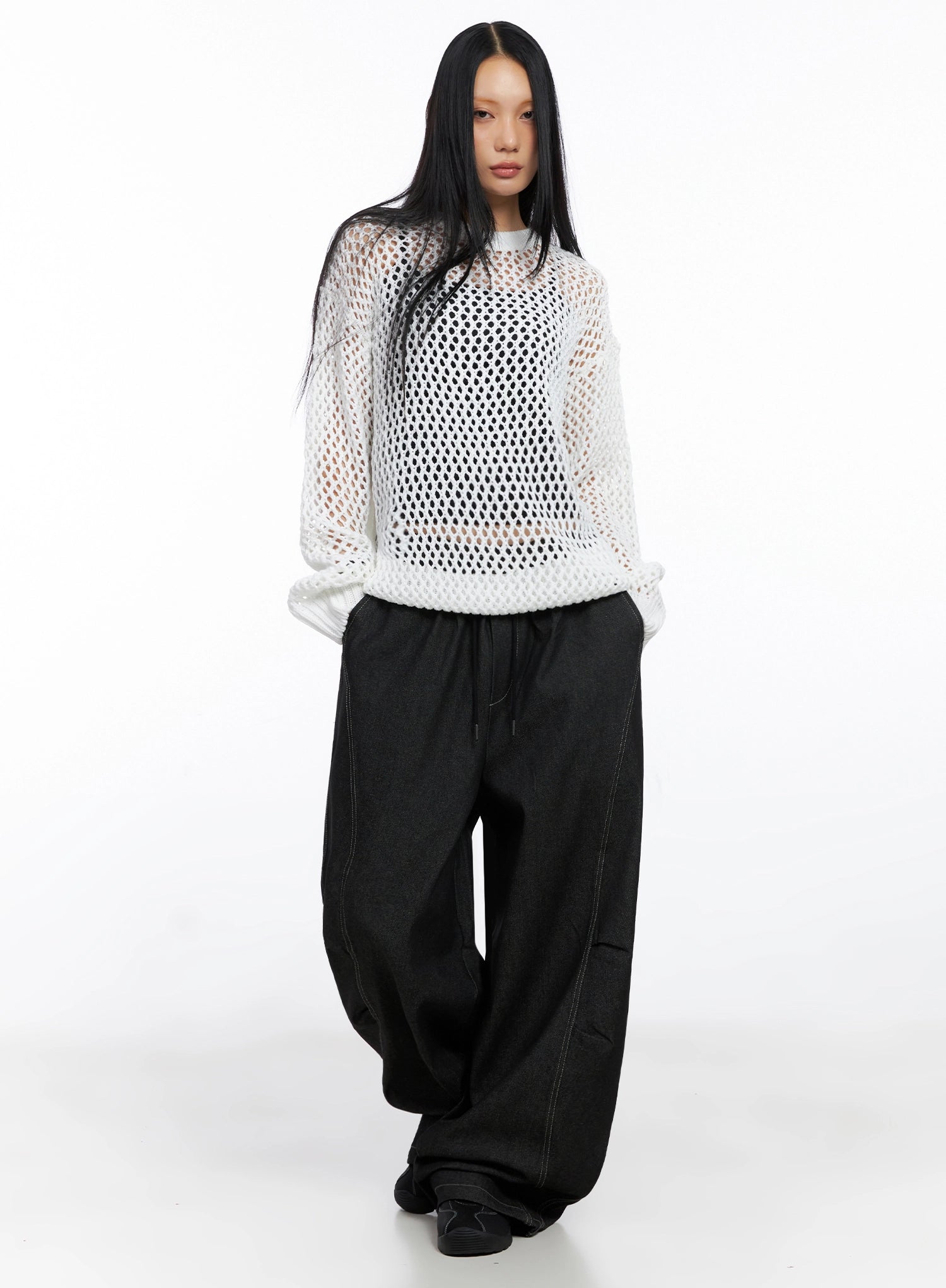 Ayra Graphic Baggy Jeans IO516 in Black, front full-body on model, styled with white open-knit mesh top, extra-wide cotton denim leg pooling at floor, street-casual acubi look.