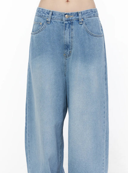 Nella Wide Leg Jeans CU519 in blue, waist close-up on model, light-wash denim detailing front pockets, button fly, belt loops, and faded wash texture.