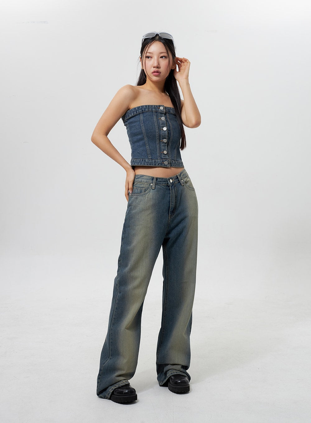 Low Rise Wide Leg Jeans CY323 in vintage blue, full-length front shot on model with relaxed pose, low-rise waistband, wide flared leg with faded wash, styled with denim bandeau top and black platform boots.