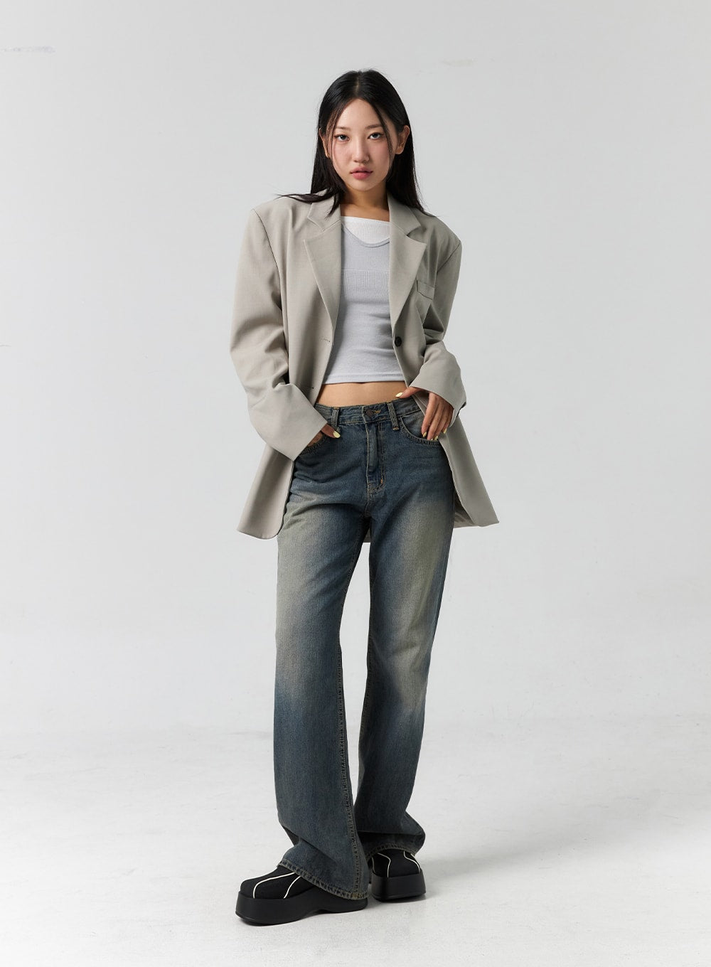 Vintage Wash Bootcut Jeans CS305 in blue, full-body front on model, relaxed stance, vintage-washed cotton denim bootcut silhouette, layered with oversized beige blazer and white crop top.