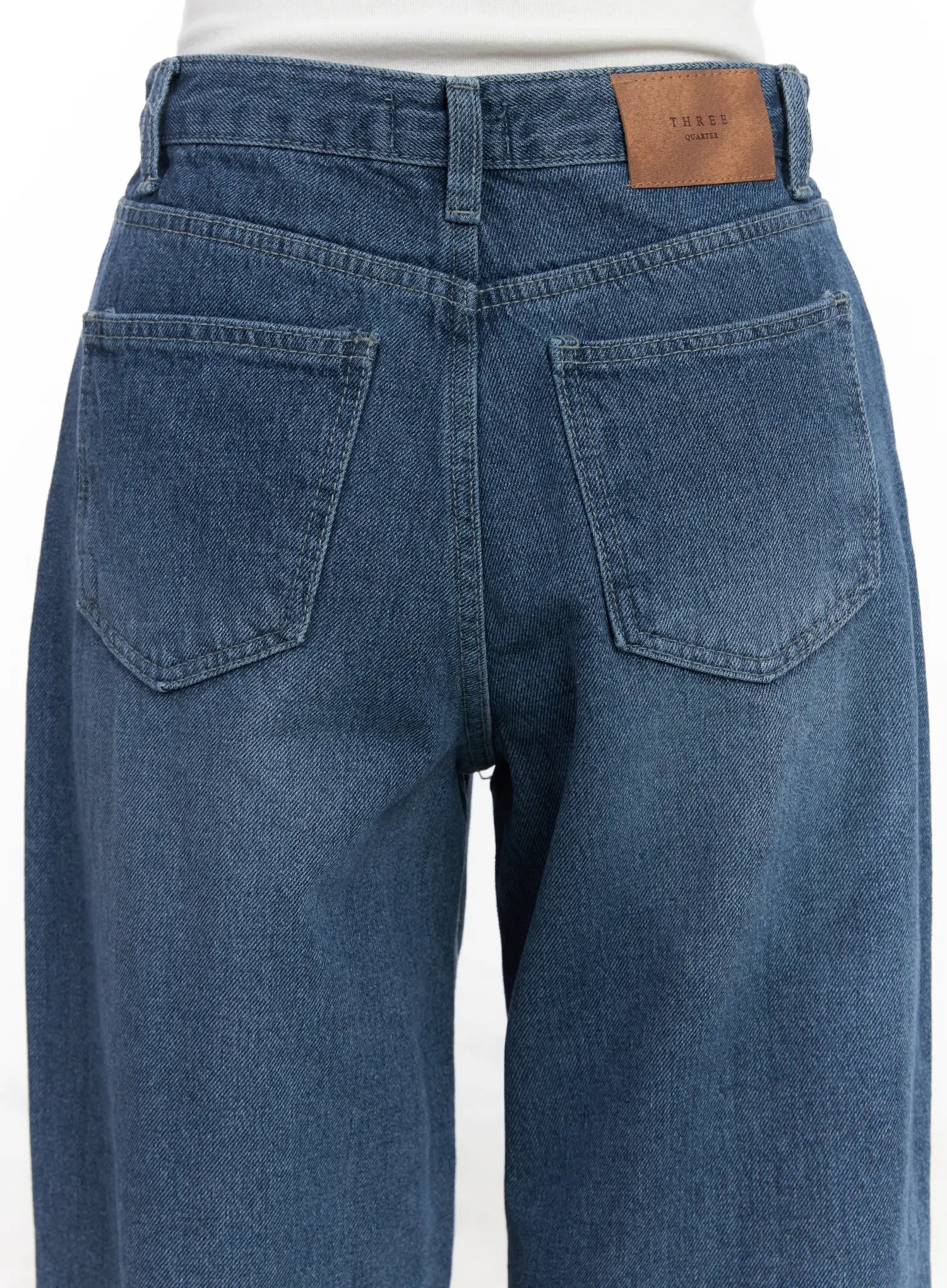 Mariam Baggy Jeans CN526 in blue, close-up back waist detail, showing dual back pockets, washed denim texture, and leather brand label on waistband.