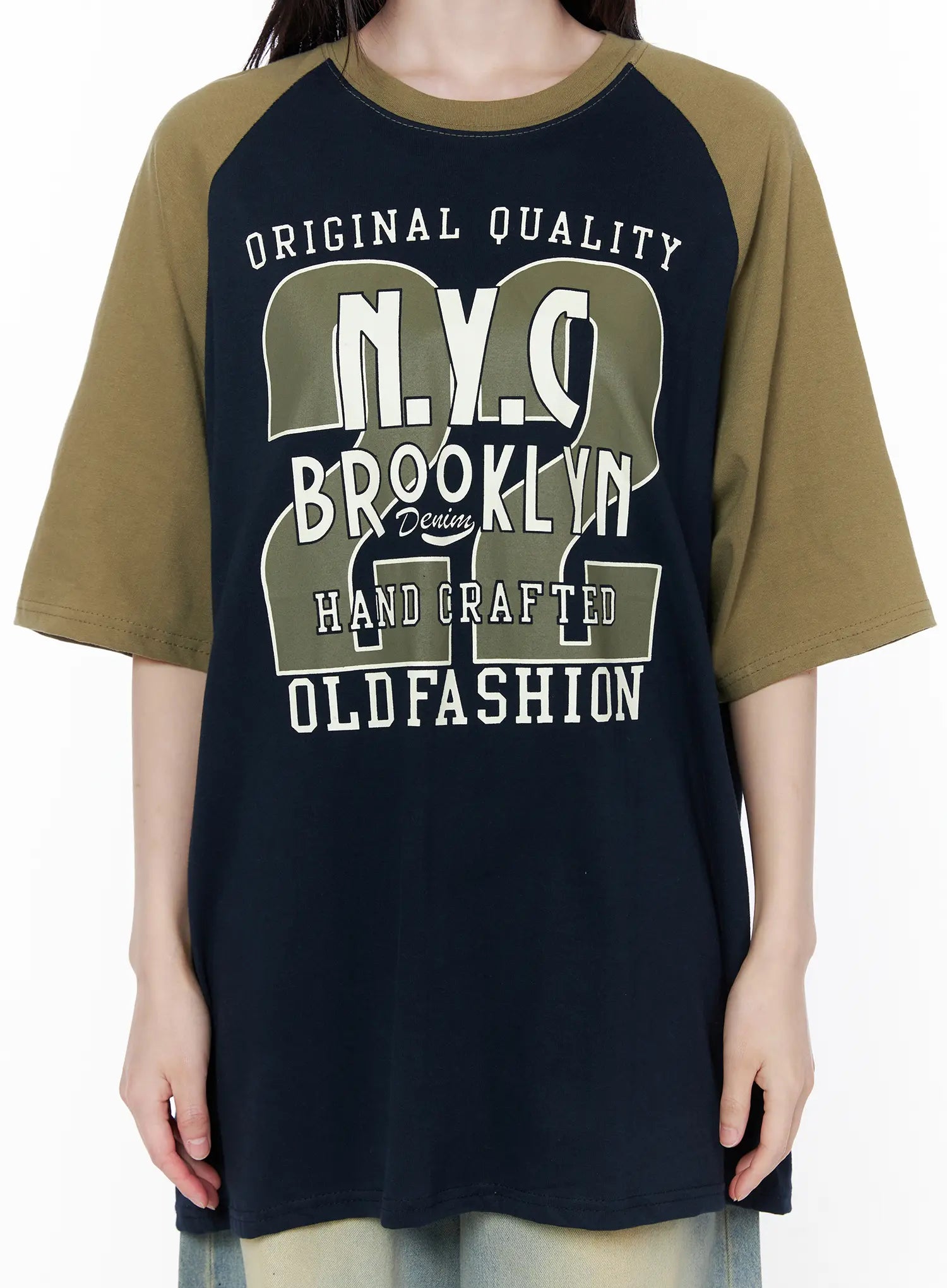 Casual Loose Fit Graphic Tee CU519 in dark blue, front graphic close-up on model torso, detailed NYC Brooklyn Old Fashion varsity-style print in olive and cream on navy cotton body, raglan seam visible.