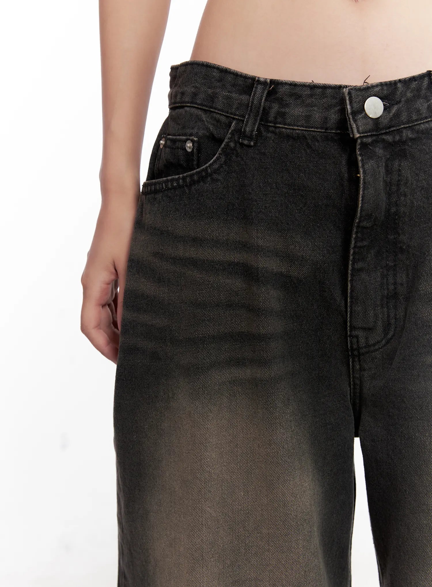 Ari Washed Wide-Leg Denim Jeans CL521 in Black, front waistband close-up on model, low-rise fit with coin pocket, silver button, and washed brown-fade denim texture detail.