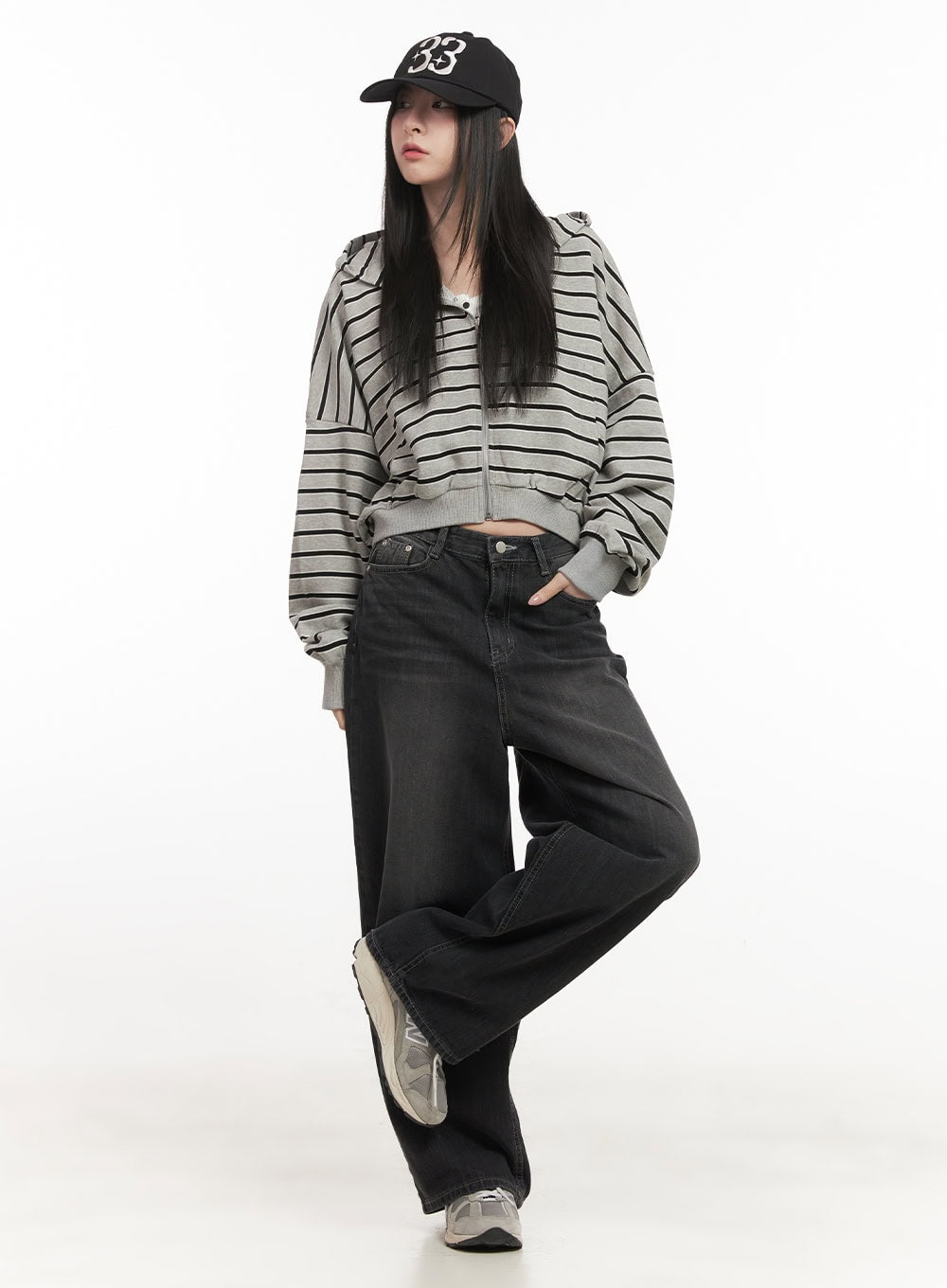Ruth Washed Wide-Leg Jeans CF514 in black, front three-quarter view on model, wide-fit washed denim with visible waistband, styled with striped crop zip hoodie and cap.