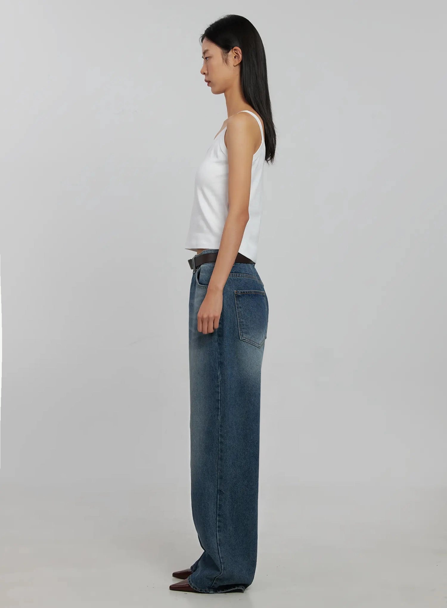 Akira Wide Leg Jeans IJ508 in blue, full side profile on model, floor-grazing wide-leg washed denim showing side seam volume, with white cami and belt.