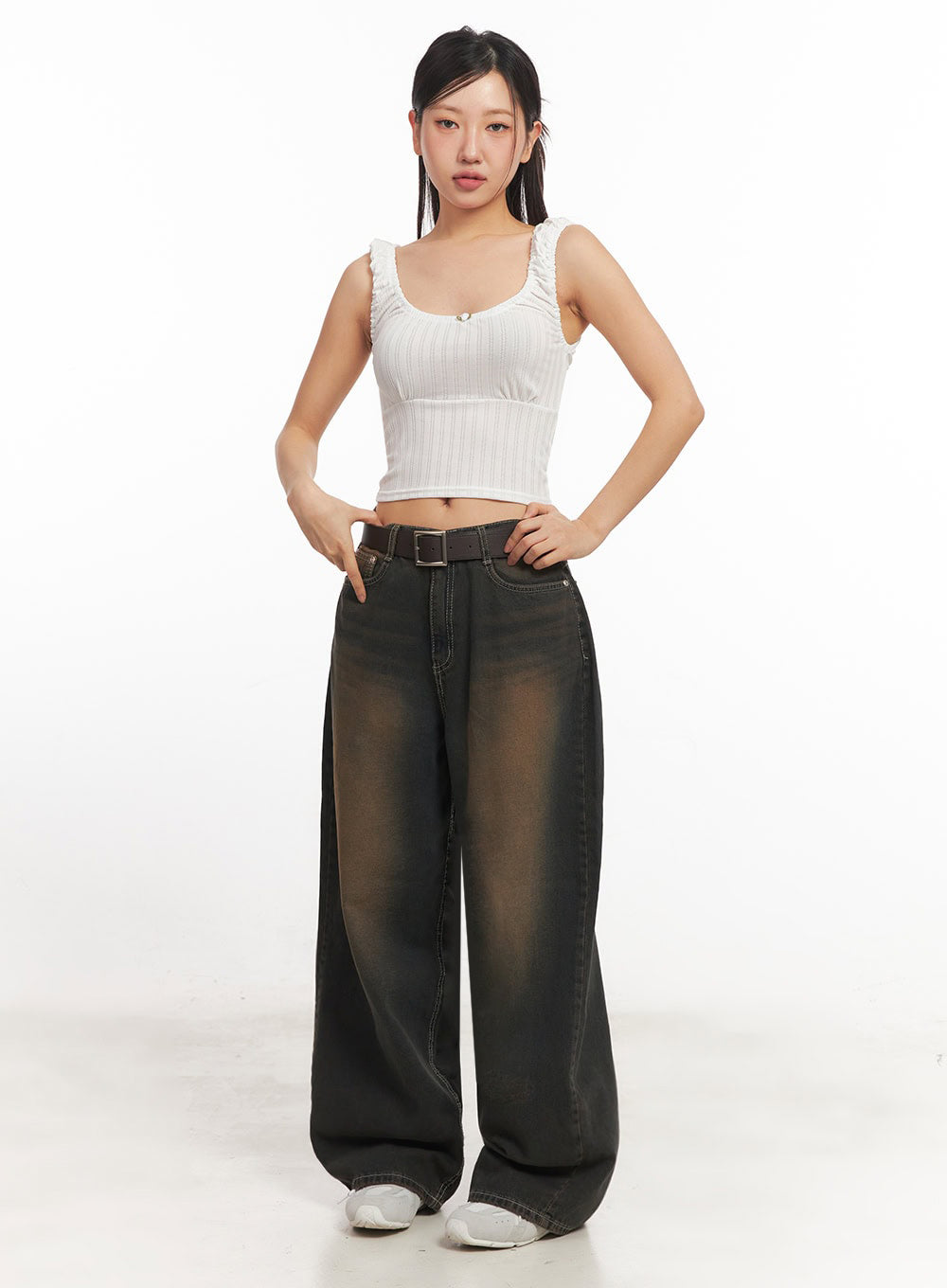 Bethany Vintage Washed Baggy Jeans IA524 in dark brown washed denim, front full-length view on model hands on hips, wide-fit with contrasting brown washed fade, brown belt, paired with white ribbed crop tank.