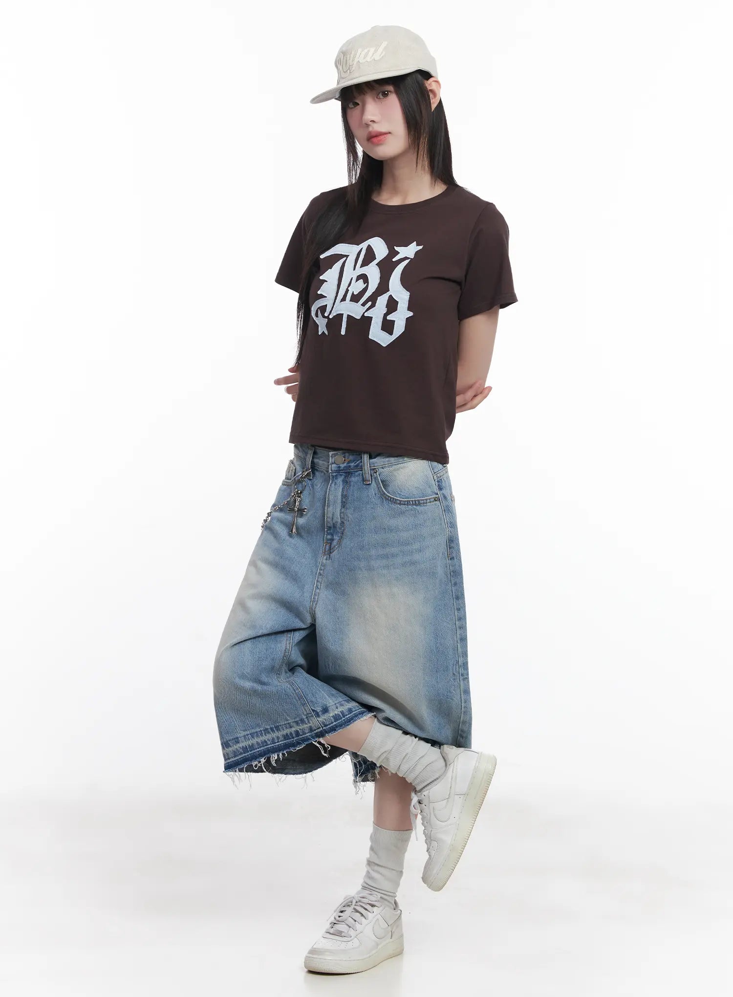 Light Wash Vintage Jorts CU519 in blue, front three-quarter on model with cap, wide midi jorts flaring outward, frayed hem and vintage wash, styled with brown graphic crop tee and sneakers.