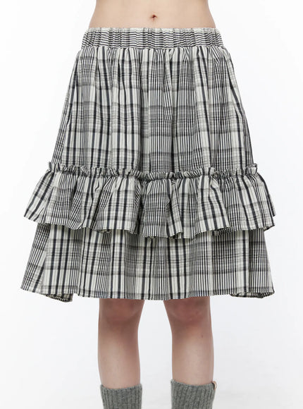 Plaid Layered Midi Skirt CU519 in black, close-up front detail shot on model, smocked elastic waistband and double gathered ruffle tiers clearly visible, black-white plaid woven fabric.