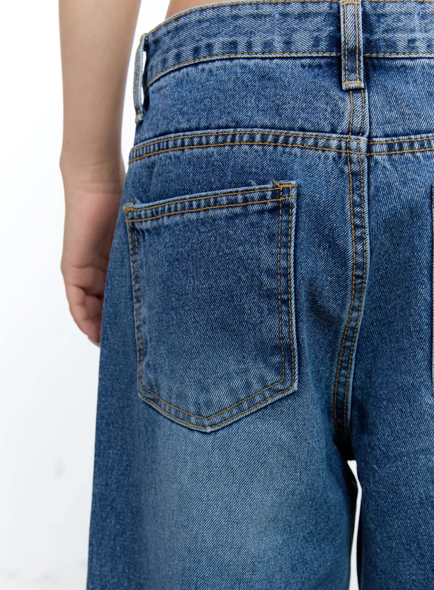 Dahye Washed Relaxed-Fit Denim Jeans CL530 in blue, macro close-up of back pocket, gold contrast topstitching, washed indigo cotton denim texture clearly visible.