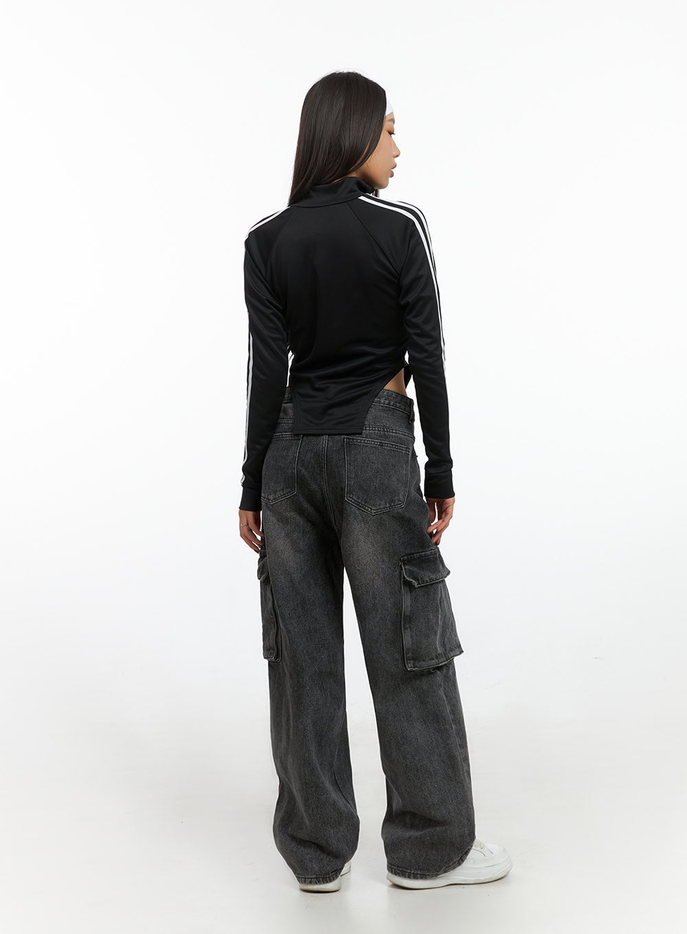 Neve Washed Cargo Denim Jeans IS427 in washed black, back full-length shot on model, revealing rear cargo pockets on thighs and wide-leg hem pooling at white sneakers, street style look.