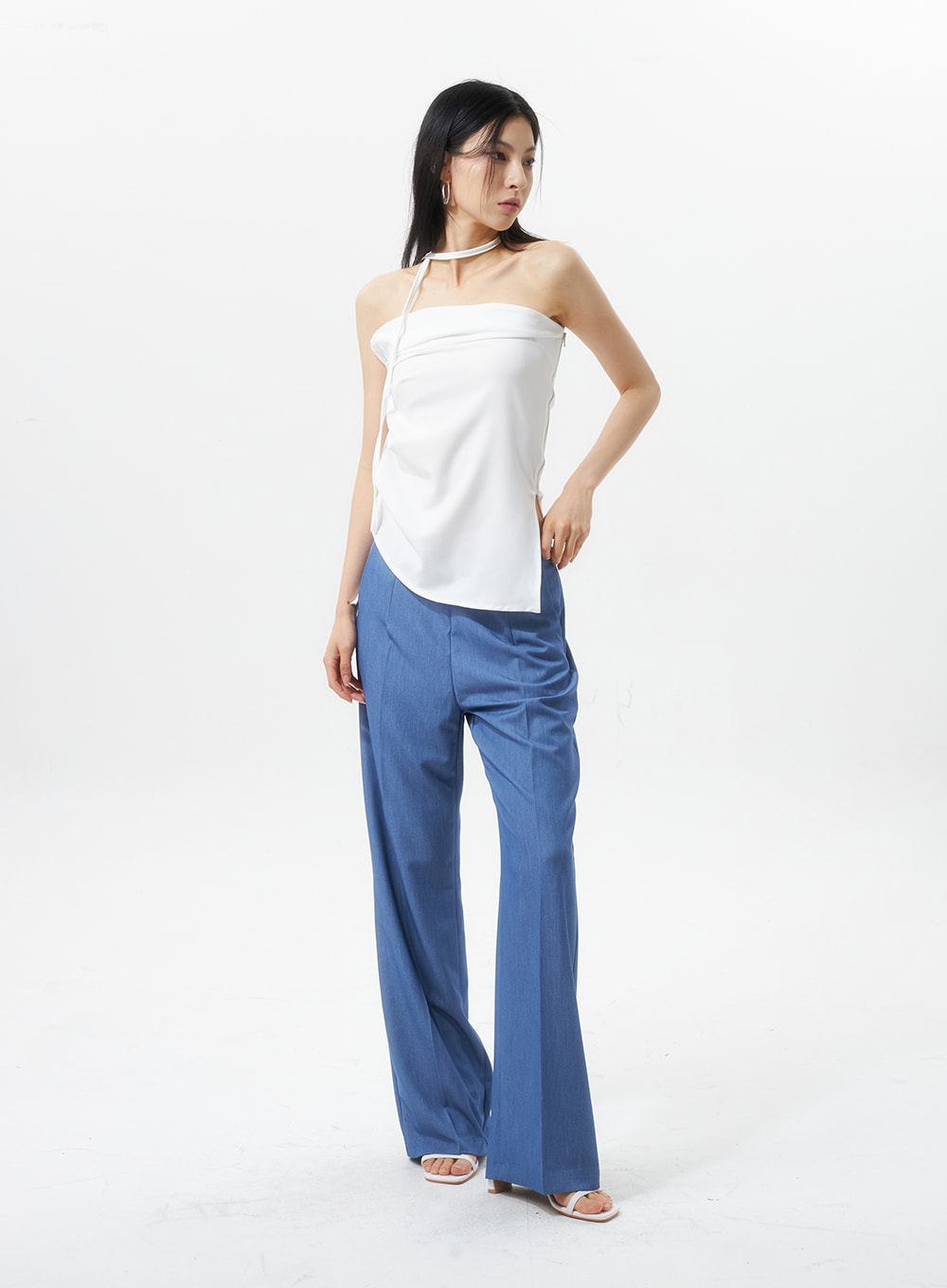 Low Rise Tailored Pants IU326 in blue, three-quarter side view on model looking away, wide-leg tailored cut with low rise, subtle heathered texture, styled with white halter top.