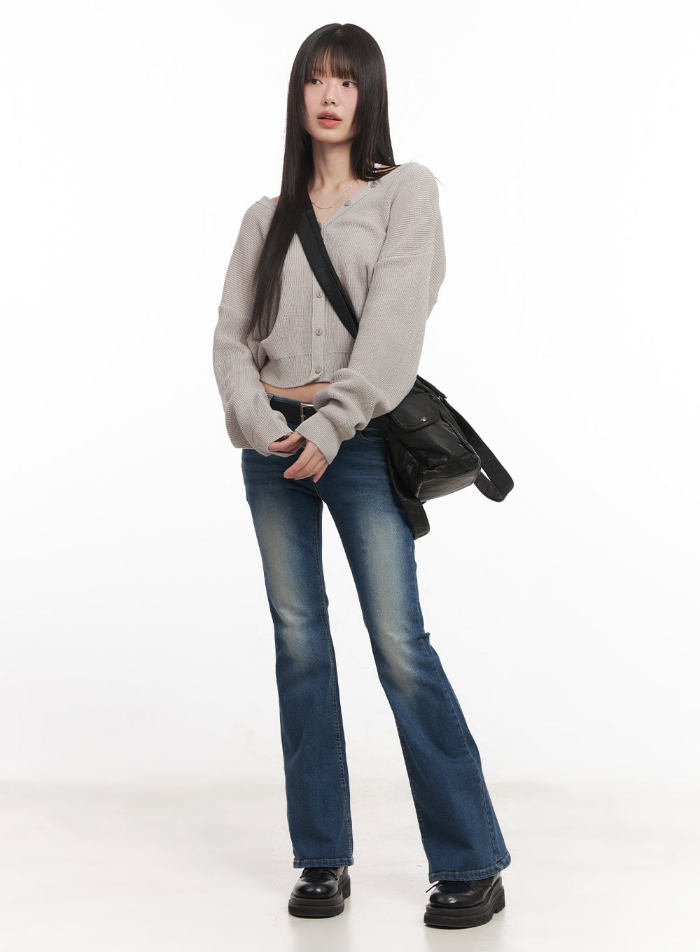 Rebecca Low-Waist Flared Jeans CM519 in dark blue, full-body front on model in beige knit crop cardigan, black crossbody bag, and black loafers, casual street style look.