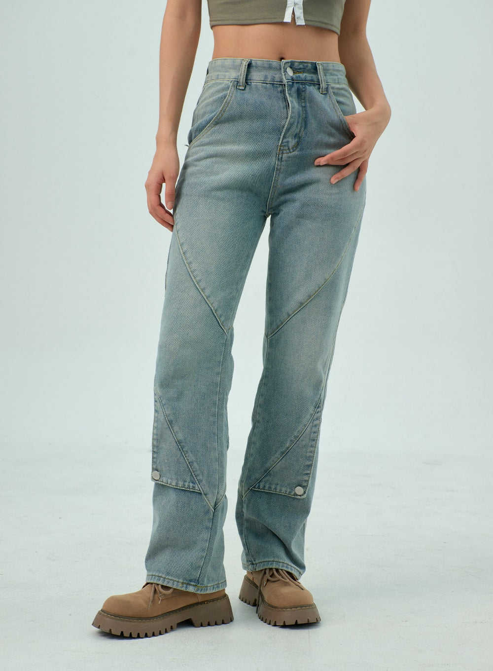 Straight Leg Jeans CY330 in light blue wash, front side-angle close-up from waist to ankle, washed denim with curved panel seams and snap button detail near hem, hand resting on hip.