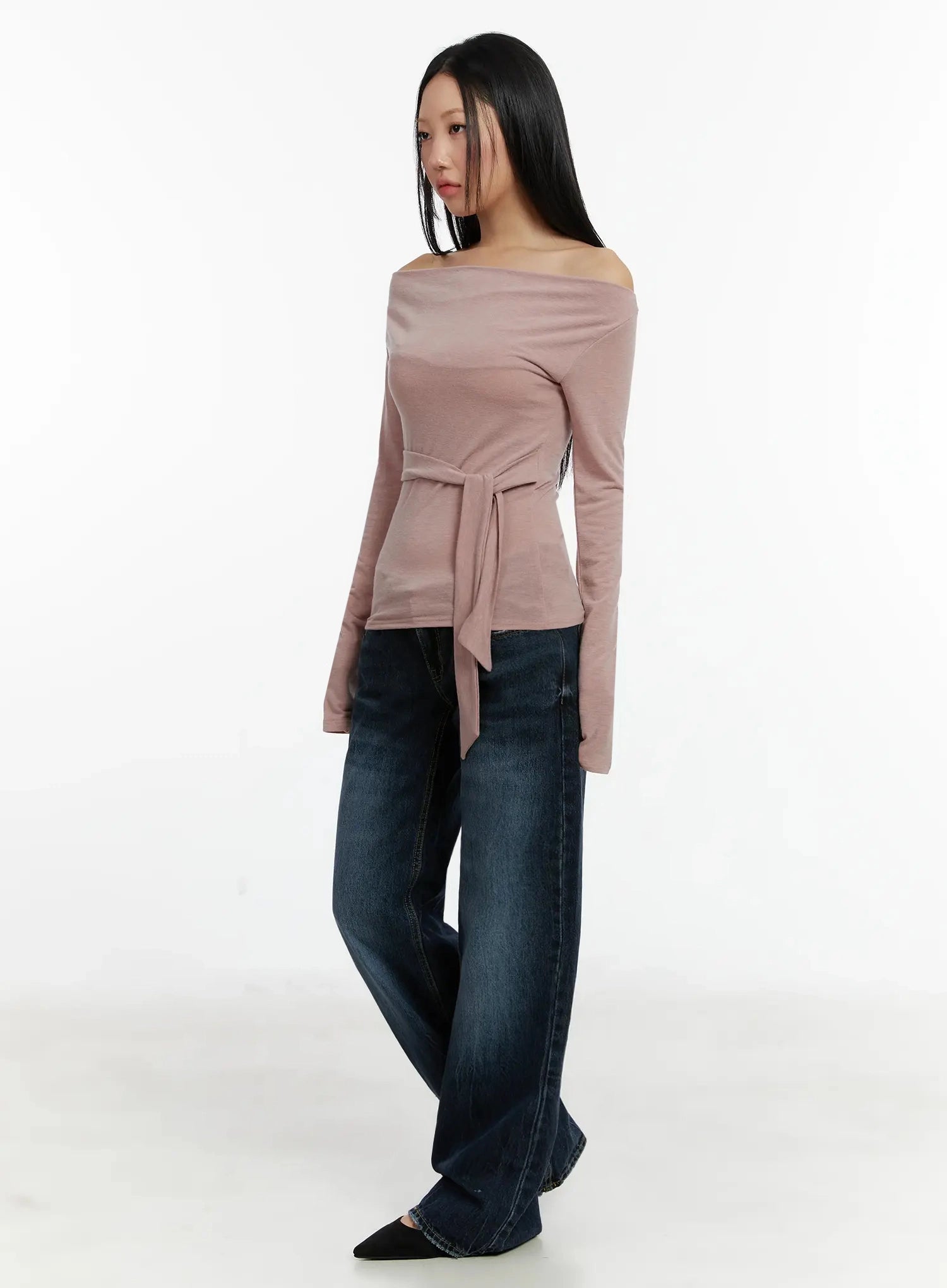 Aimee Low Rise Wide Leg Jeans ID525 in dark blue wash, three-quarter side shot on model, wide leg with washed fading, low-rise waist, paired with dusty pink off-shoulder belted top.