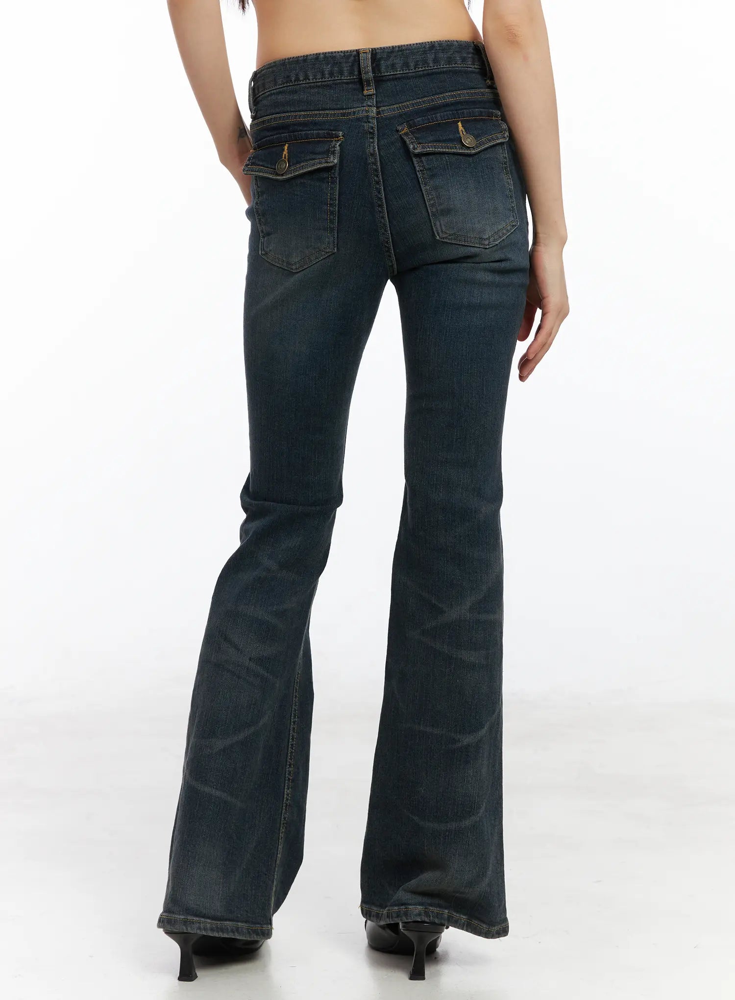 Kai Vintage Washed Flare Jeans CD515 in dark indigo, back full-length view on model, bootcut flare silhouette with dual back flap pockets and gold topstitching, worn with black heels.