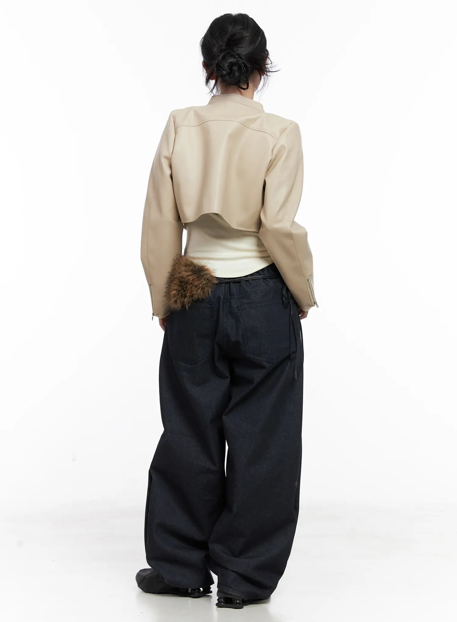 Solana Unwashed Wide-Leg Jeans CN514 in dark indigo, full-body back on model, voluminous wide-leg silhouette, back pockets and elastic waist shown, styled with beige cropped jacket and fur bag.