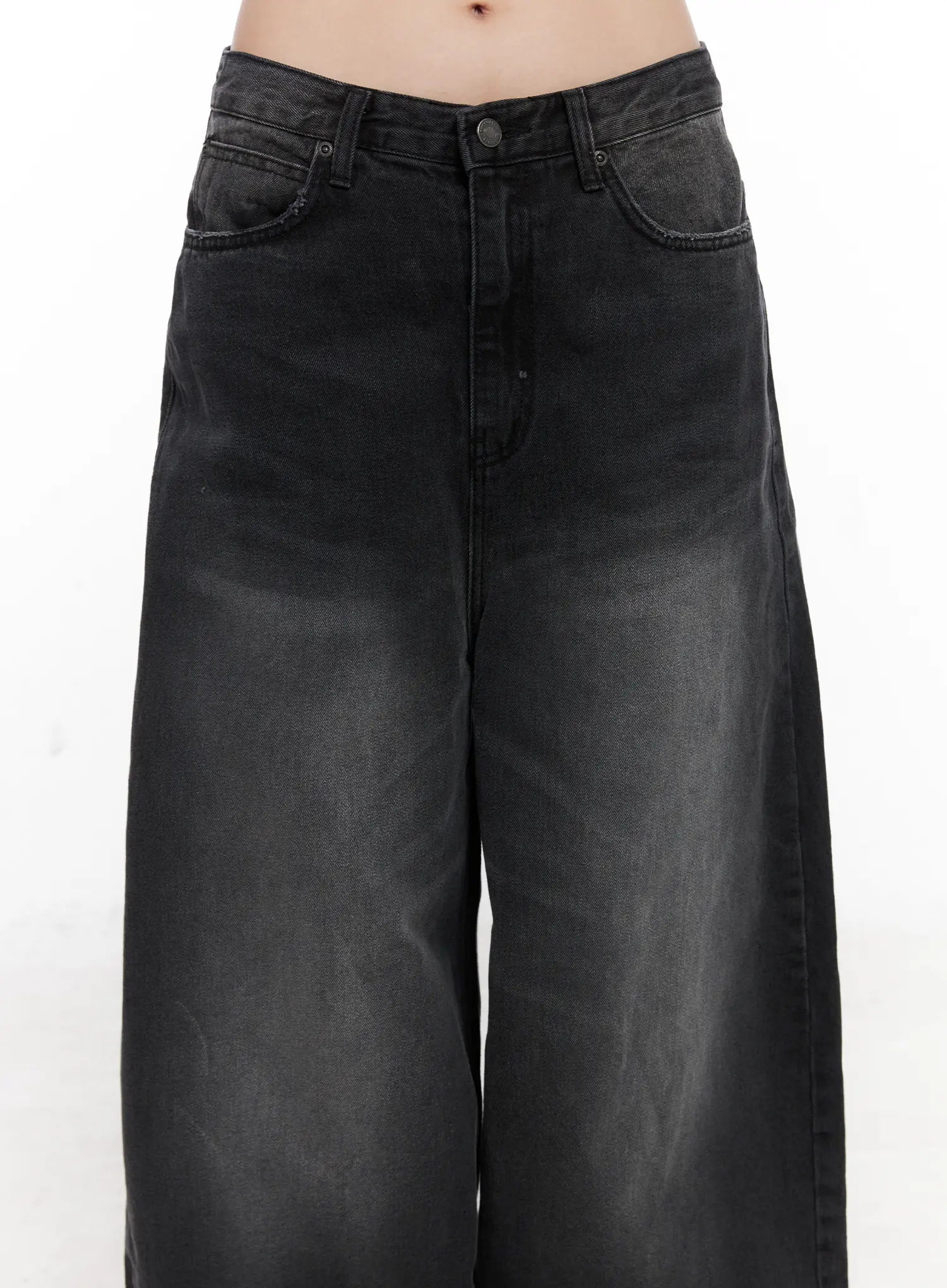 Yuji Dark-Washed Baggy Jeans CN513 in black, close-up front detail of waistband and thigh area on model, showing button fly, coin pocket, five-pocket construction, and dark-washed cotton denim texture.