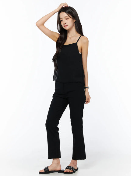 Sheer Ribbon Cami Top CU522 in black, three-quarter front view on model, square neck, thin straps, sheer crinkle fabric, paired with black flare trousers and slide sandals.