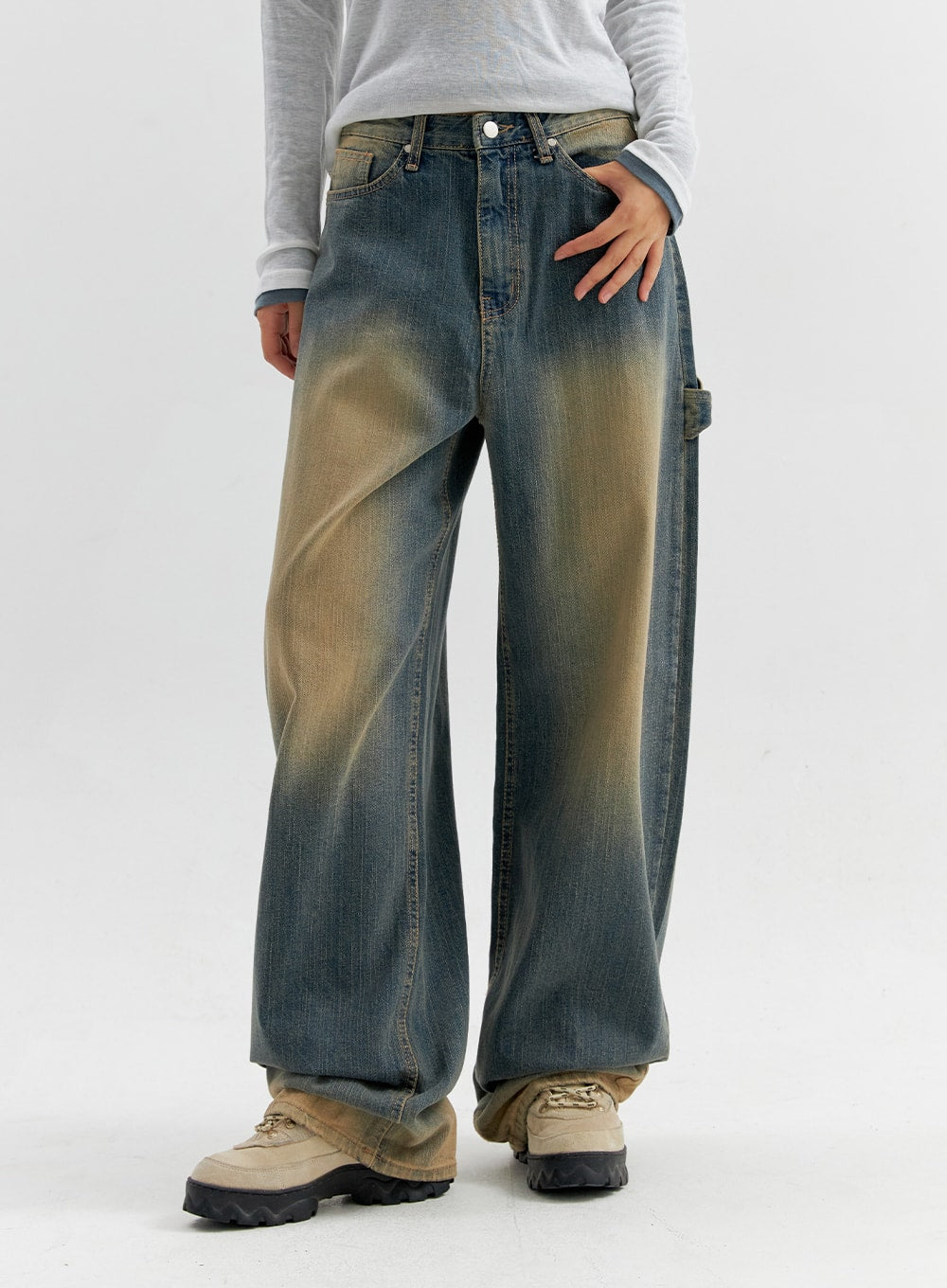 Vintage Wash Wide Leg Jeans CO306 in blue, front close-up on model, wide-leg denim with prominent yellow sun-fade on thighs, carpenter pocket detail at right hip, mid-rise waist.
