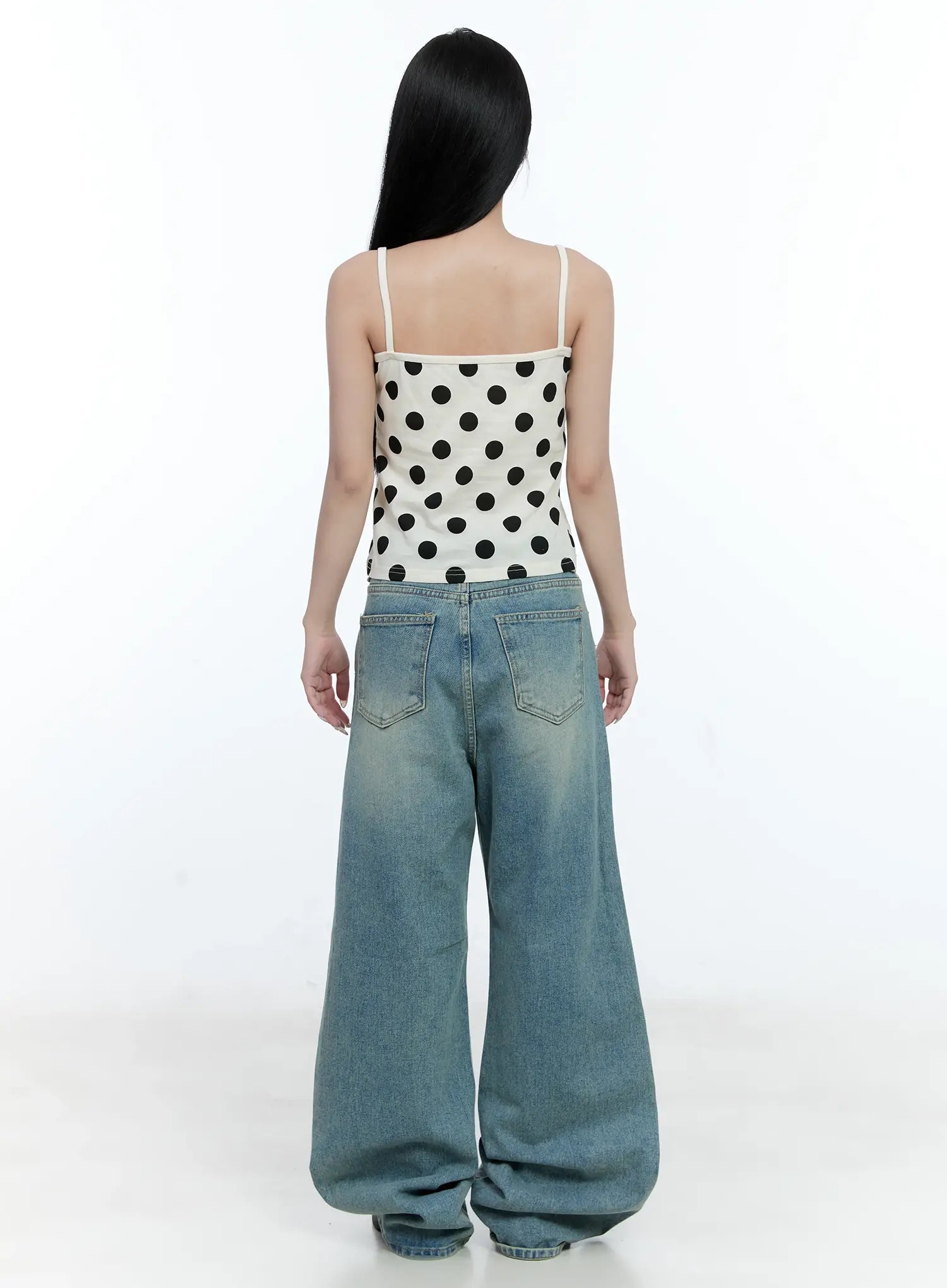 Haeun Wide-Leg Denim Jeans CG501 in blue, back full-length view on model, wide-leg washed denim with dual back pockets, styled with white polka-dot spaghetti-strap crop top.