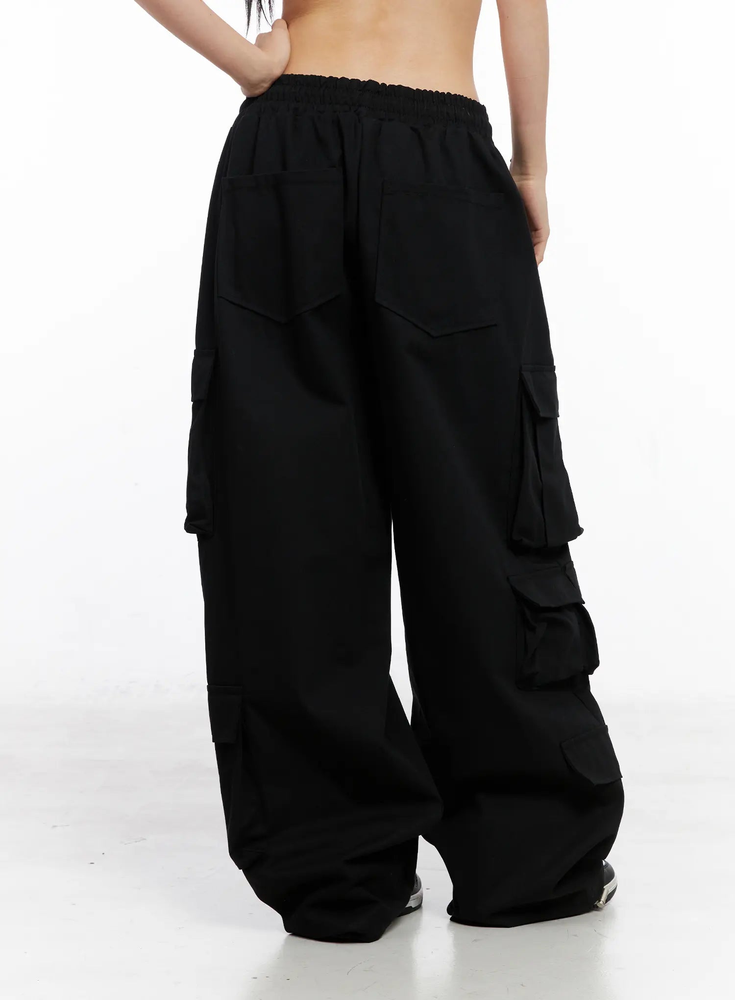 Wide Leg Cargo Pants CC1109 in black, back full-length shot on model, back patch pockets and multi-flap side cargo pockets, wide pooling leg, elastic waist.