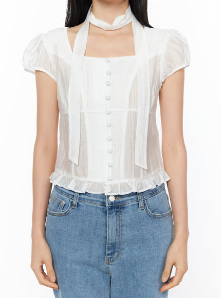 Puff Sleeve Shirred Blouse with Scarf IU519 in white, cropped front close-up on model, square neckline, center button placket, sheer shirred fabric, ruffled hem, and scarf detail clearly shown.