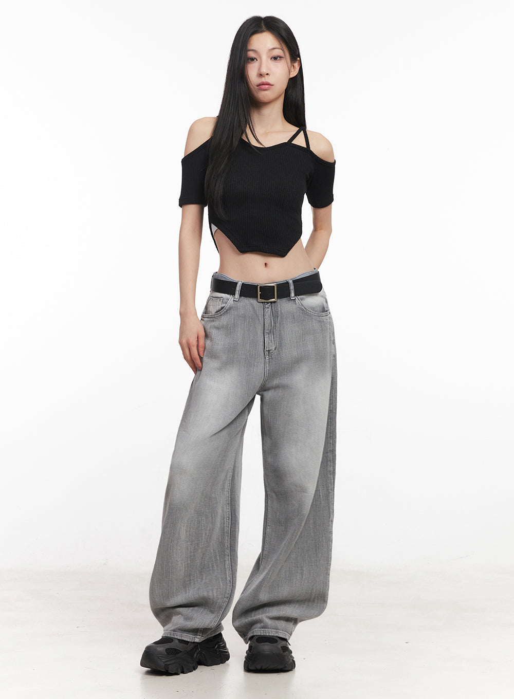 Flore Washed Wide-Leg Jeans IY516 in gray, full-body front shot on model, wide-leg washed denim with black belt, paired with black cold-shoulder ribbed crop top and chunky sneakers.