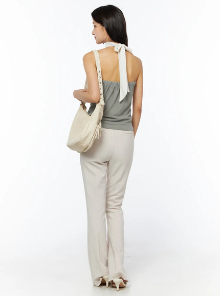 Neck-Tie Halter Top CU522 in dark green, full-length back view with styling, open back and cream neck-tie bow, model carrying cream shoulder bag with cream flare trousers and heels.