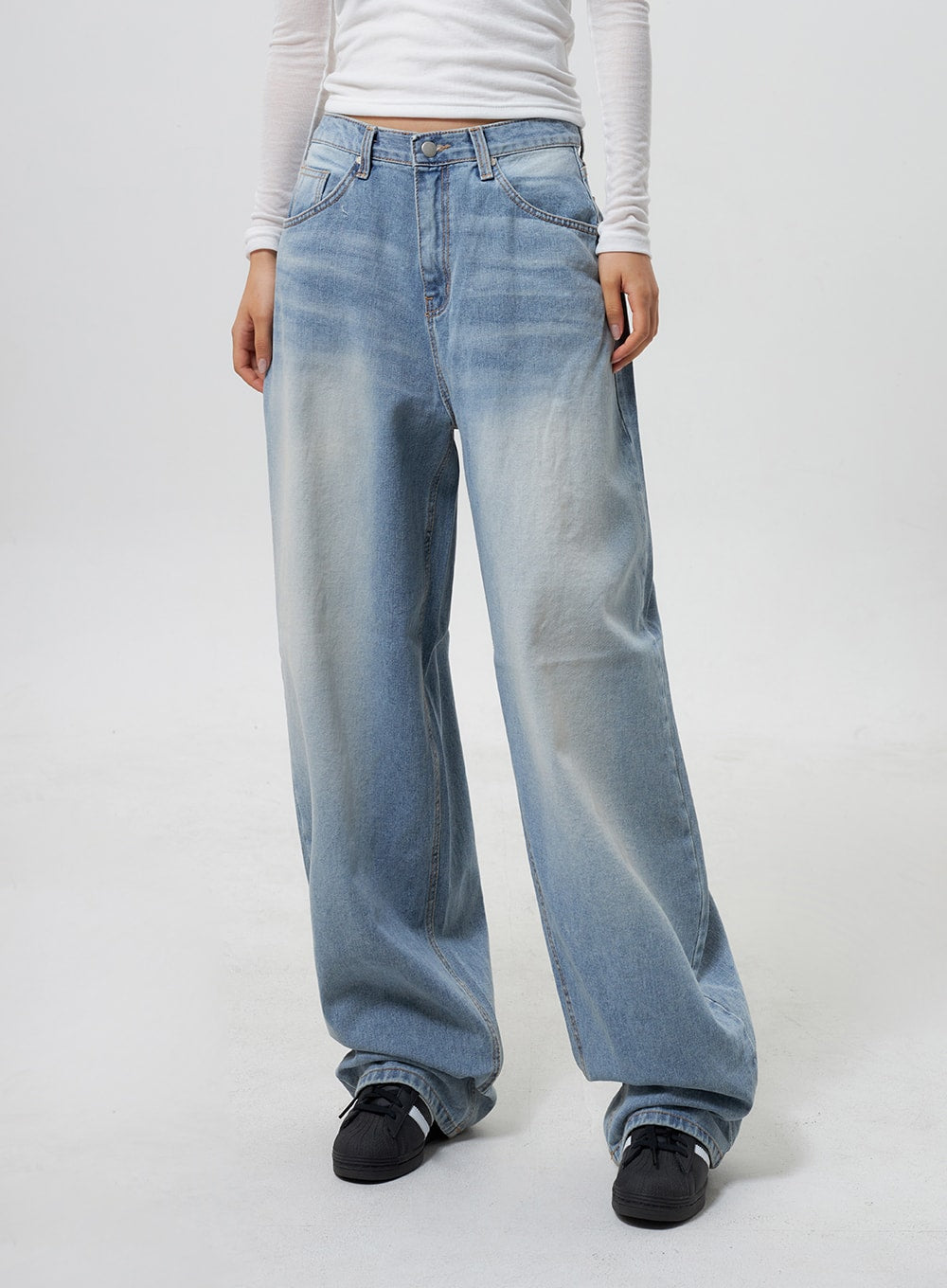 Low Rise Baggy Jeans CY324 in light blue, front waist-to-hem close-up on model, low-rise five-pocket construction, heavy faded wash, extra-wide baggy leg in cotton denim, white ribbed top visible.
