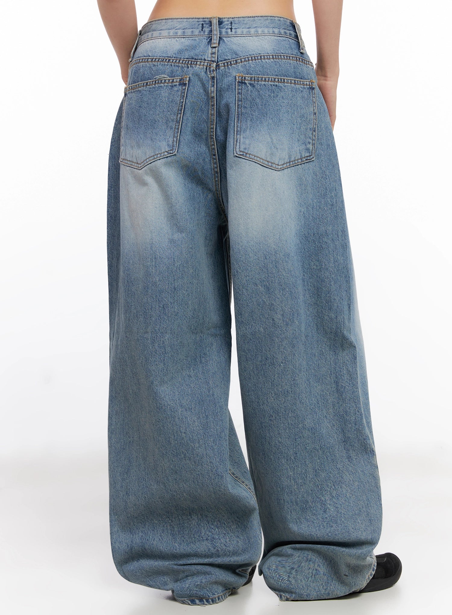 Seojin Washed Wide-Leg Jeans IG508 in blue, back view on model, highlighting two back patch pockets, waistband stitching, and washed wide-leg denim pooling at hem.
