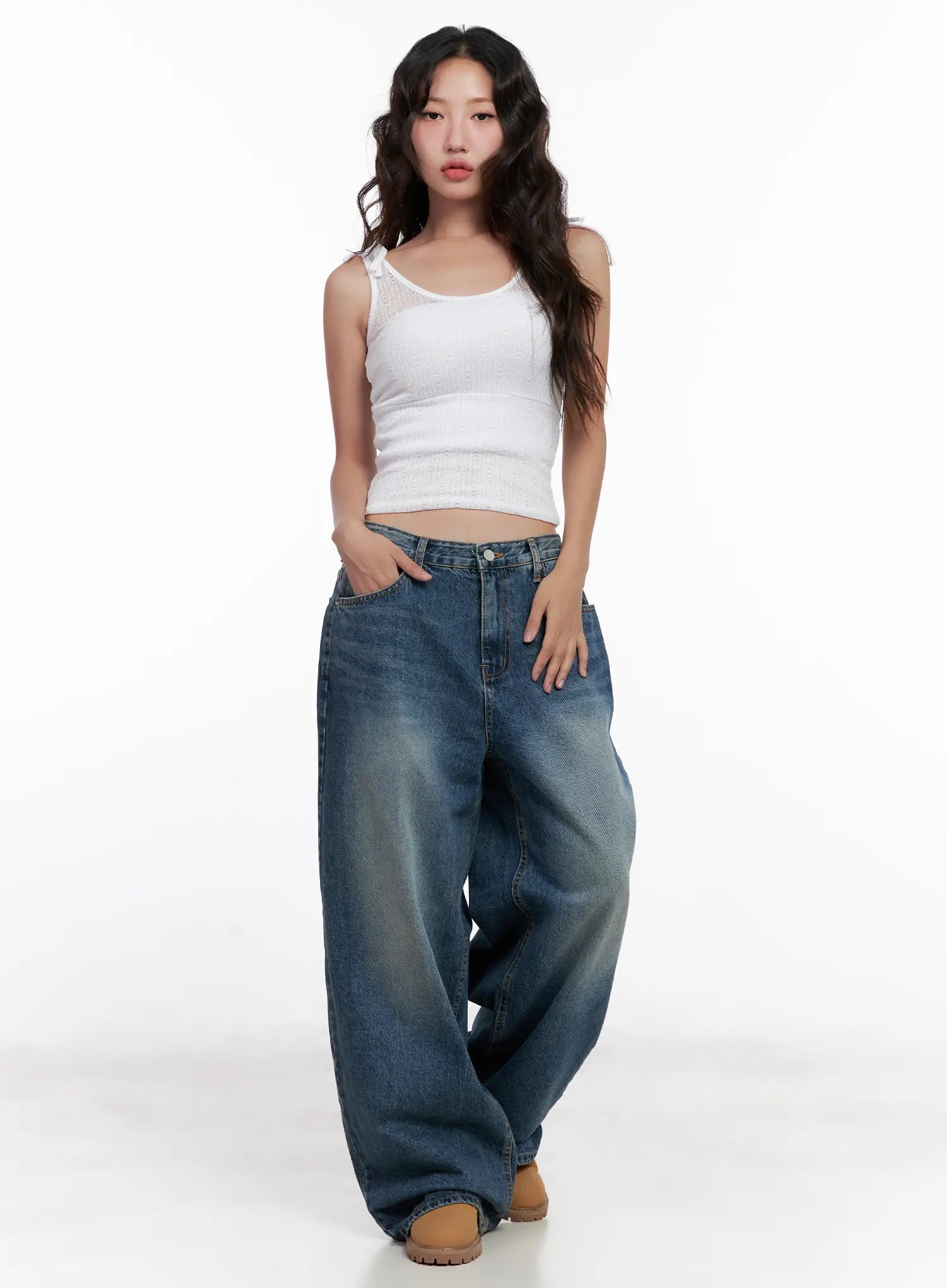Miji Wide-Leg Washed Denim Jeans CL521 in dark blue, full-body front shot on model hand in pocket, voluminous wide-fit washed denim, paired with white ribbed crop tank top and tan boots.