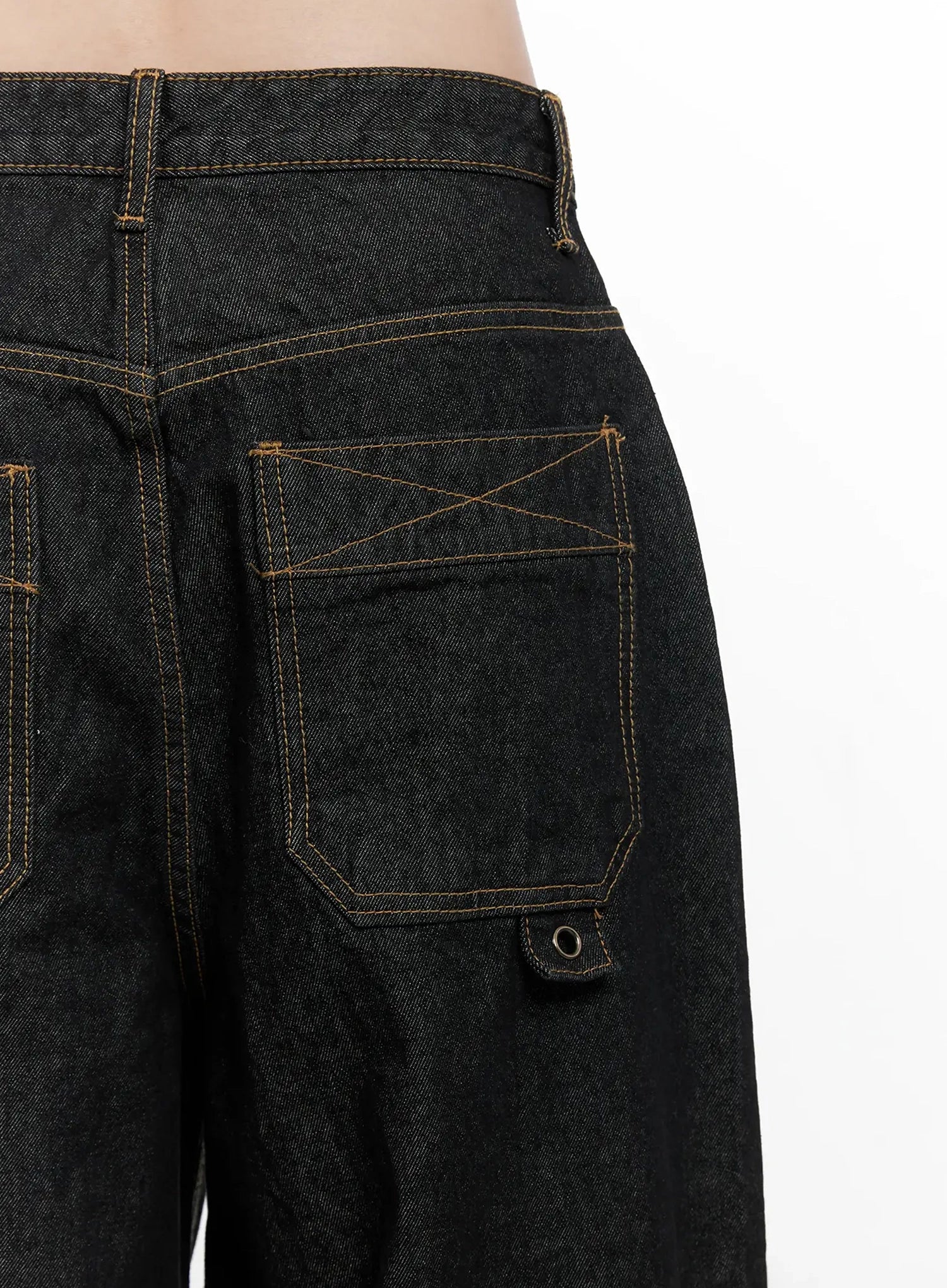 Halo Wide Leg Stitch Detail Jeans IN514 in black, macro close-up of back pocket detail, X-shaped cross-stitch embroidery, rivet hardware, and bold contrast gold topstitching on raw cotton denim.