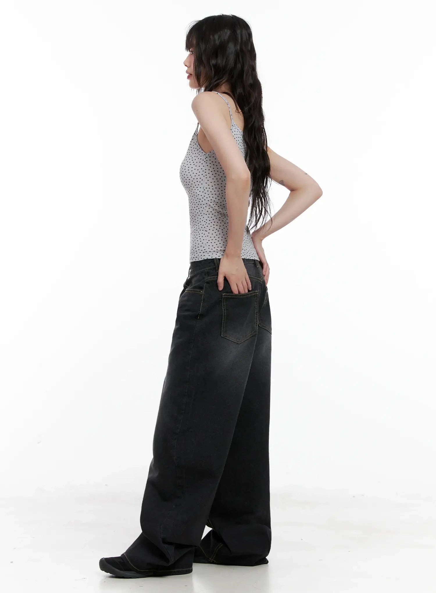 IU Vintage Black Baggy Jeans IL528 in black, side full-length shot on model, back pocket and side silhouette visible, washed baggy wide leg, paired with polka-dot cami.