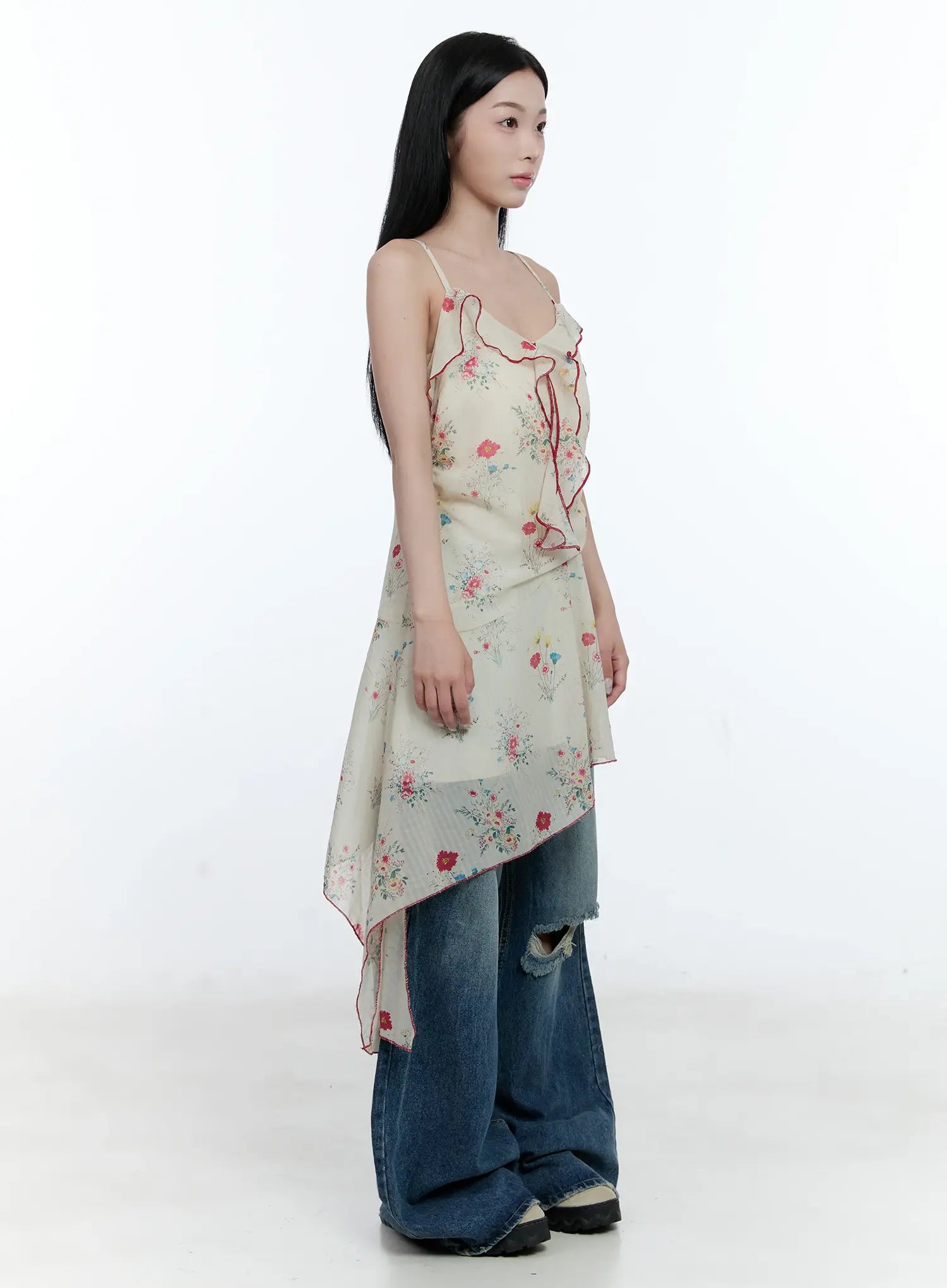Gabi Distressed Semi-Flared Denim Jeans CG501 in dark blue, three-quarter side outfit shot, knee rip and flared hem stacking visible, styled with floral ruffle cami top.