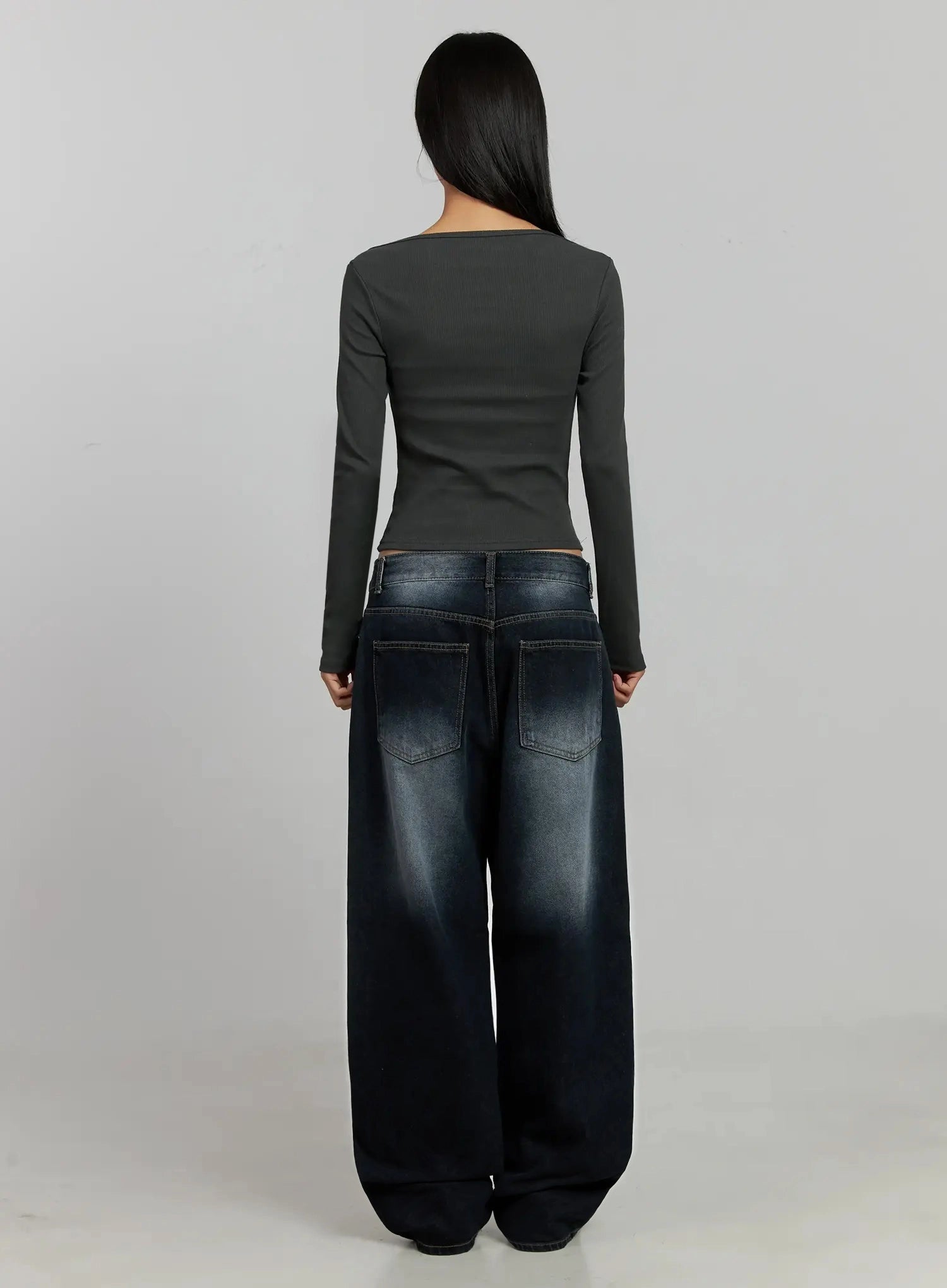 Chaya Washed Wide Jeans IJ505 in dark blue, back full-body view on model, showing two patch back pockets with contrast stitching and washed fading, styled with grey crop top.
