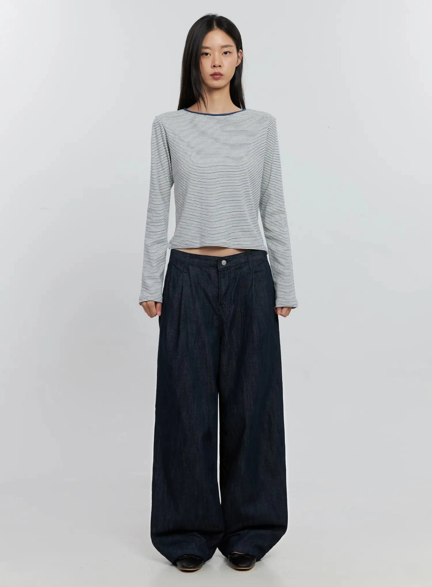 Elio Pintuck Wide-Leg Jeans IS516 in dark indigo, full-length front on model, pintuck wide-leg silhouette, styled with cropped white stripe long-sleeve top, no outerwear.