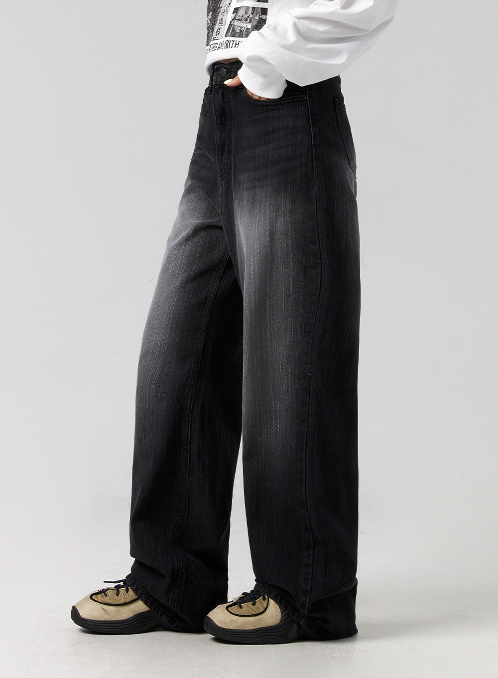 Washed Wide-Leg Jeans CG327 in black, side close-up from waist to hem on model, showing wide-leg volume and washed denim fade gradient, high-rise waist with hand in pocket, styled with white top.