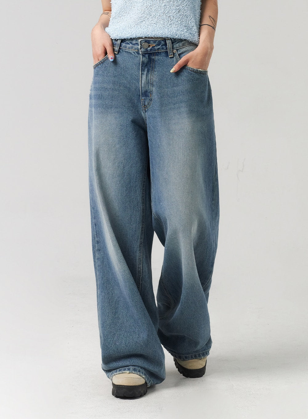 Baggy Jeans CL313 in washed blue, front mid-length close-up on model in motion, emphasising wide baggy leg, washed cotton denim with faded crease detail and floor-grazing hem.