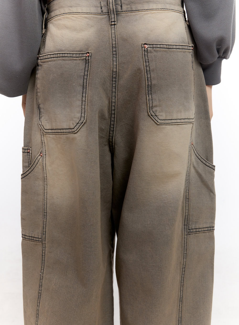 Sara Stitched Pocket Baggy Jeans CF512 in Beige, back close-up detail on model, washed cotton denim showing large patch pockets, copper rivets, and bold contrast topstitching.