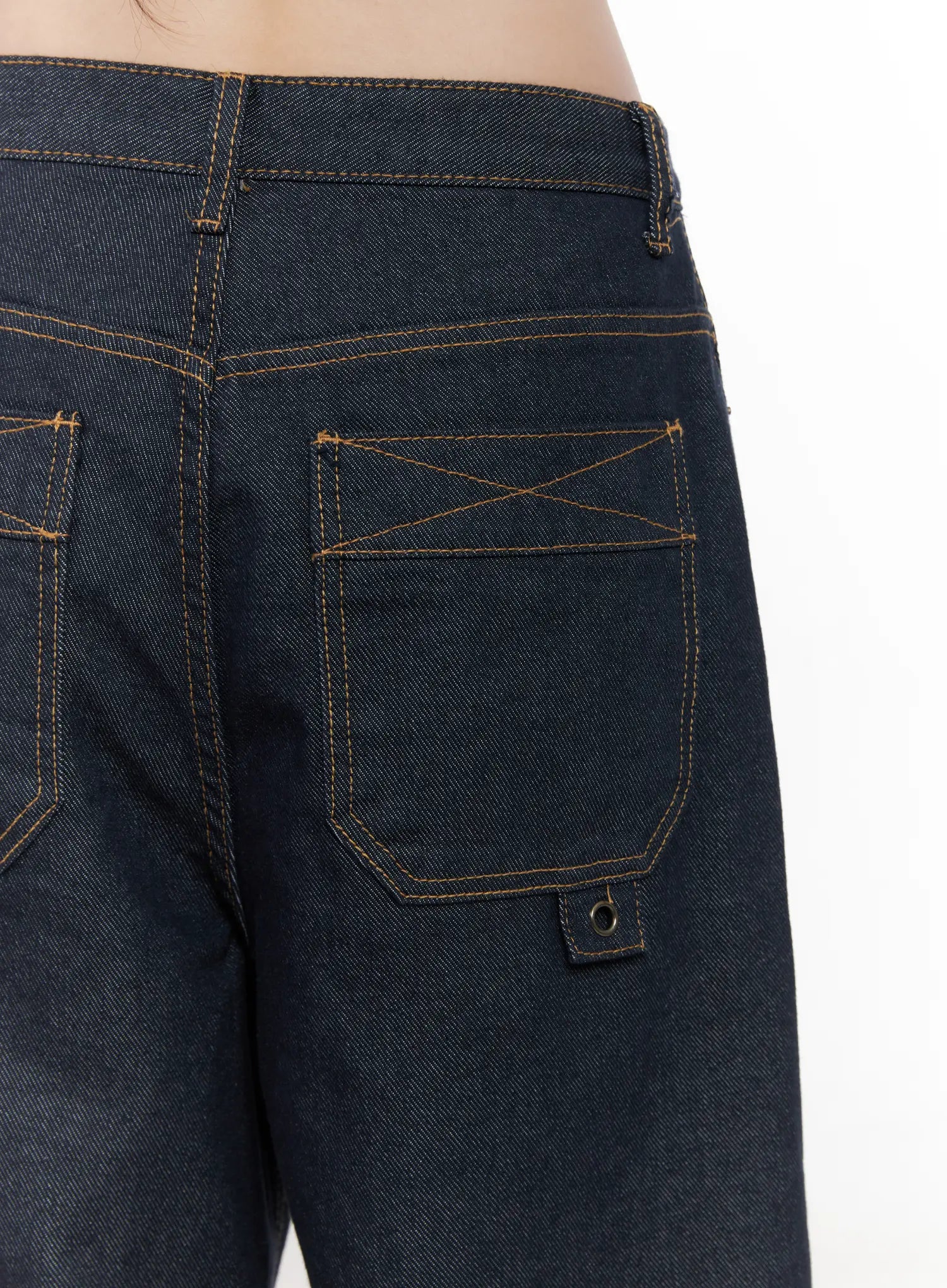 Heaven Wide-Leg Dark Washed Jeans CN513 in dark blue, macro close-up of back pocket detail, showing contrast orange cross-stitching, patch pocket construction, and branded rivet tab on cotton denim.