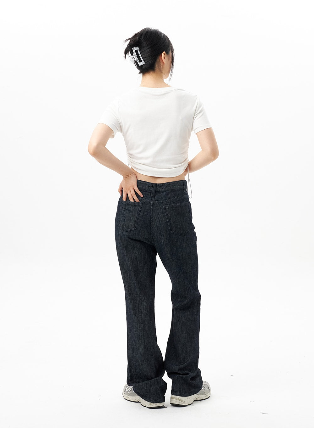 Dark Wash Mid-Rise Jeans OU314 in dark blue, back full-body view on model, bootcut flare hem, back patch pockets and mid-rise waistband, styled with white crop tee.