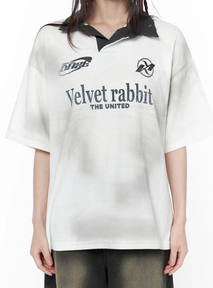 Oversized Collar Jersey CU519 in white, front chest close-up on model, oversized sporty jersey showing dark contrast polo collar, Velvet rabbit THE UNITED graphic print and logo badges in detail.