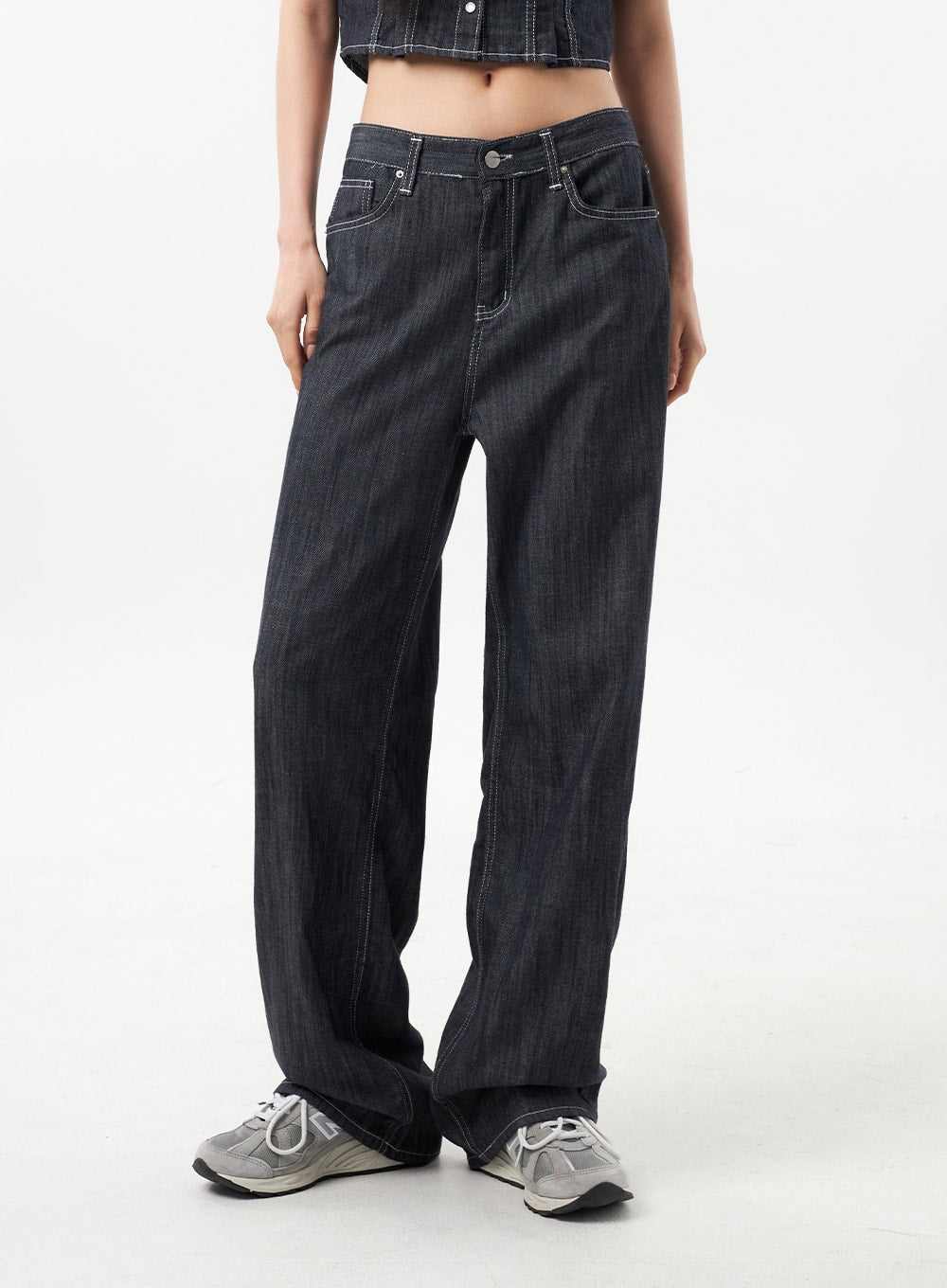 Low Rise Wide Pants CU312 in dark grey, waist-to-ankle front close-up on model, wide-leg cut with contrast white stitching along seams and front pockets, relaxed street fit over sneakers.