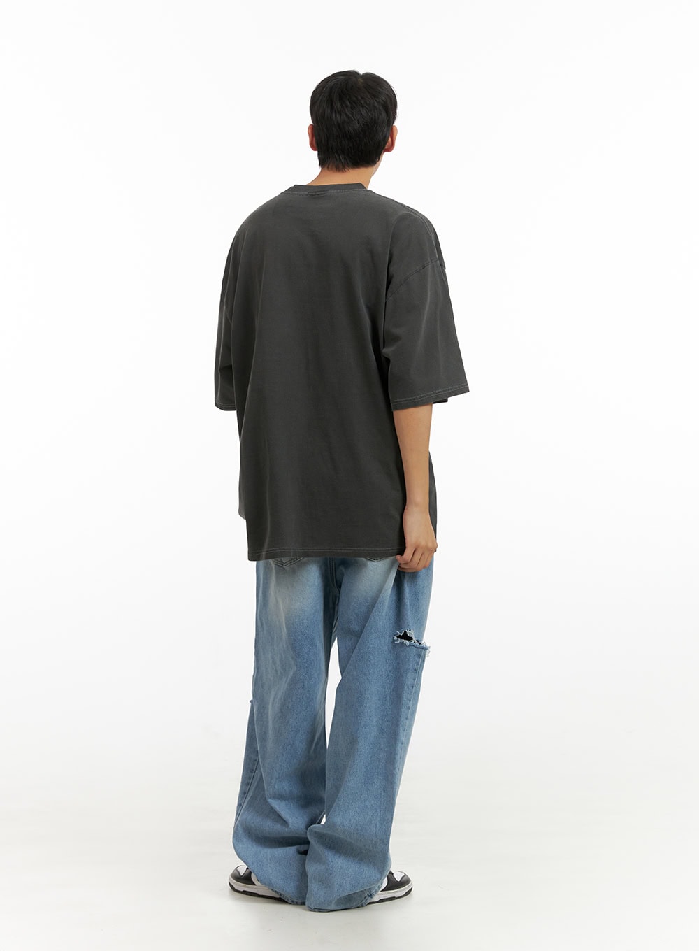 Men's Cut Out Baggy Jeans IU419 in blue, back full-length view on model, wide baggy leg with visible knee cut-out on back, paired with charcoal oversized tee and sneakers.