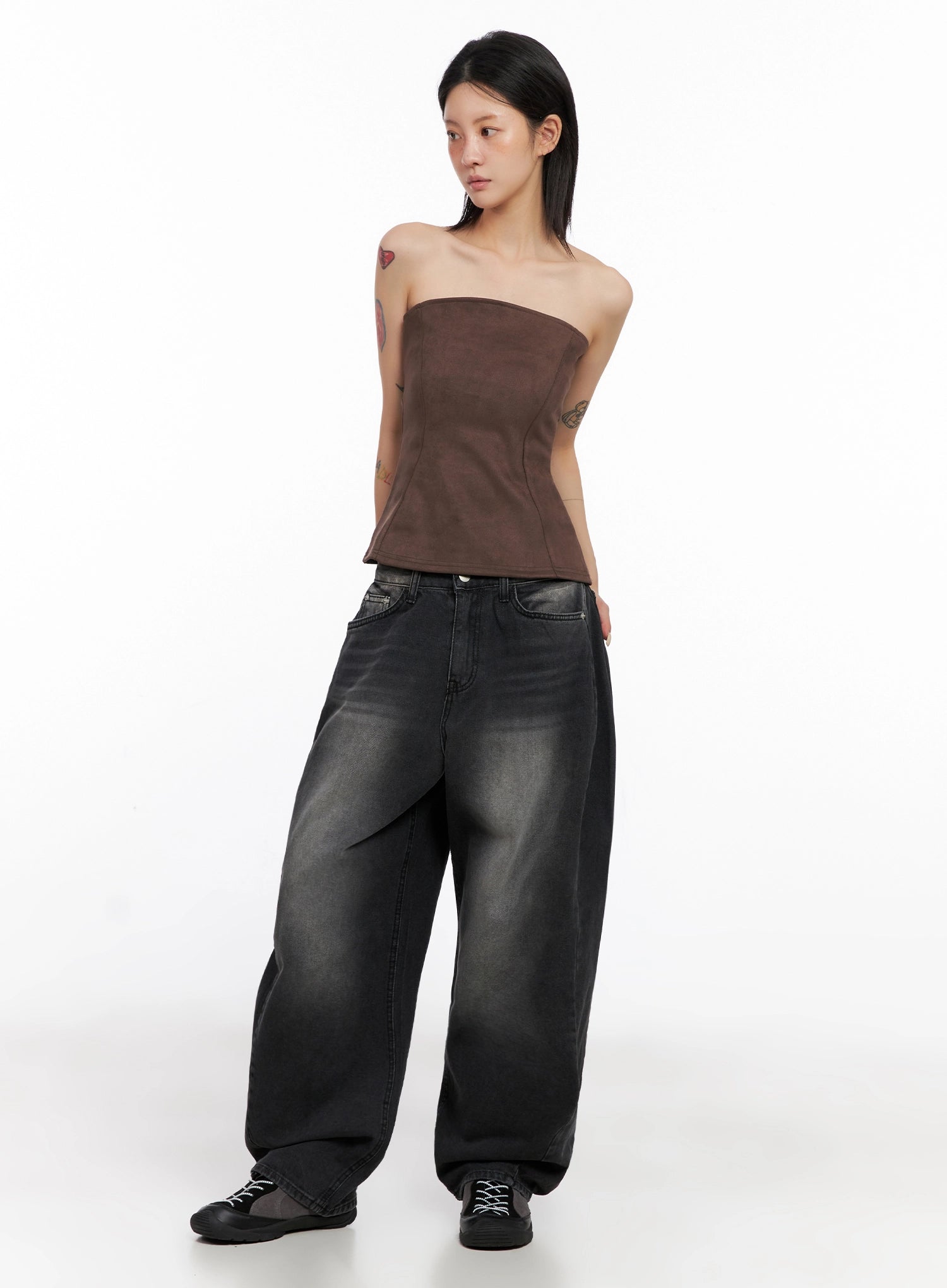 Ayra Dark Washed Baggy Jeans IS508 in dark grey, full-length three-quarter view on model looking aside, voluminous wide-leg silhouette with washed denim, styled with brown tube corset top and chunky sneakers.