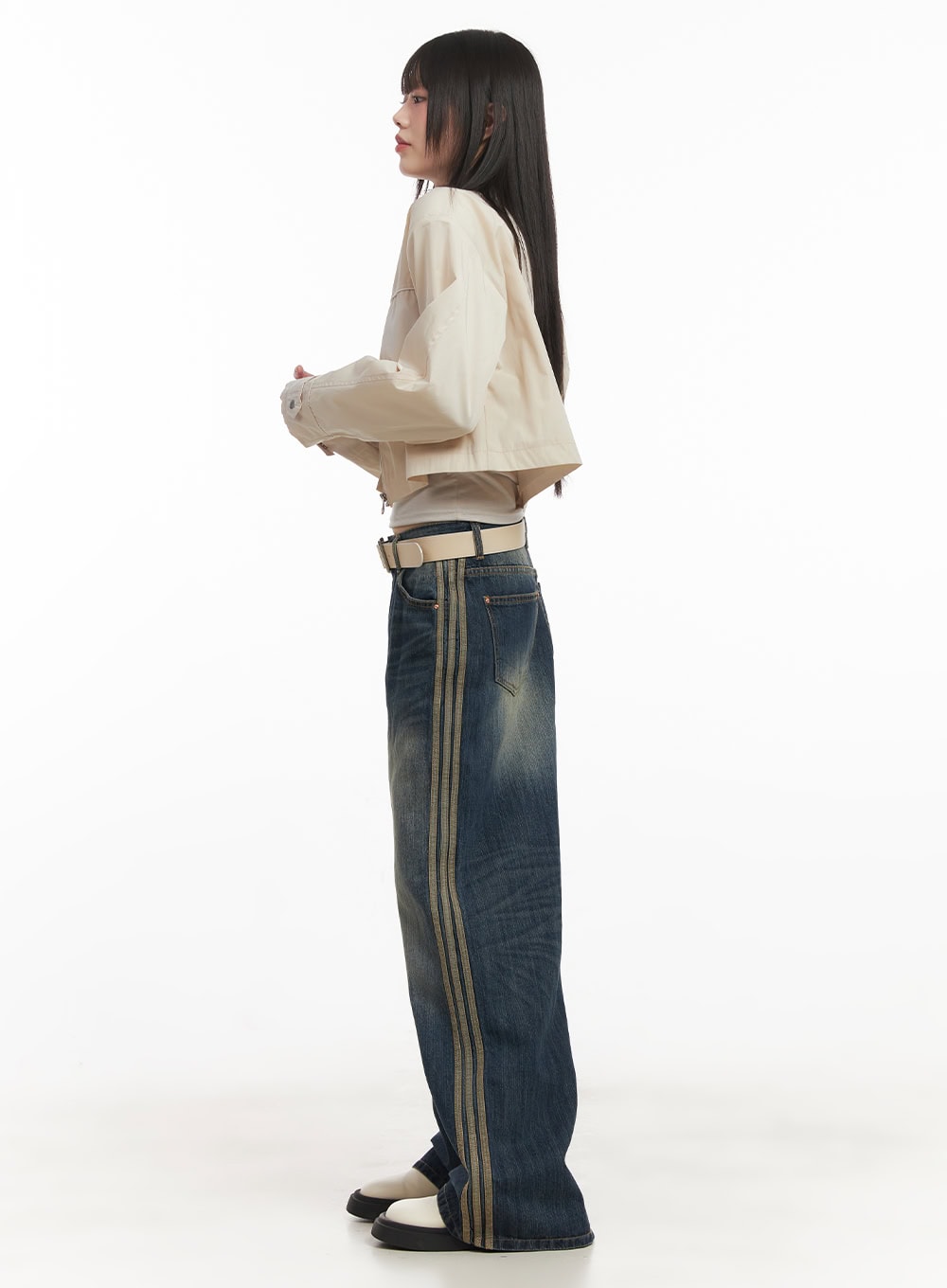 Daisee Striped Wide-Leg Jeans CF518 in dark blue, side full-length view on model, wide-leg washed denim with prominent triple gold side stripe, styled with cream cropped jacket and belt.