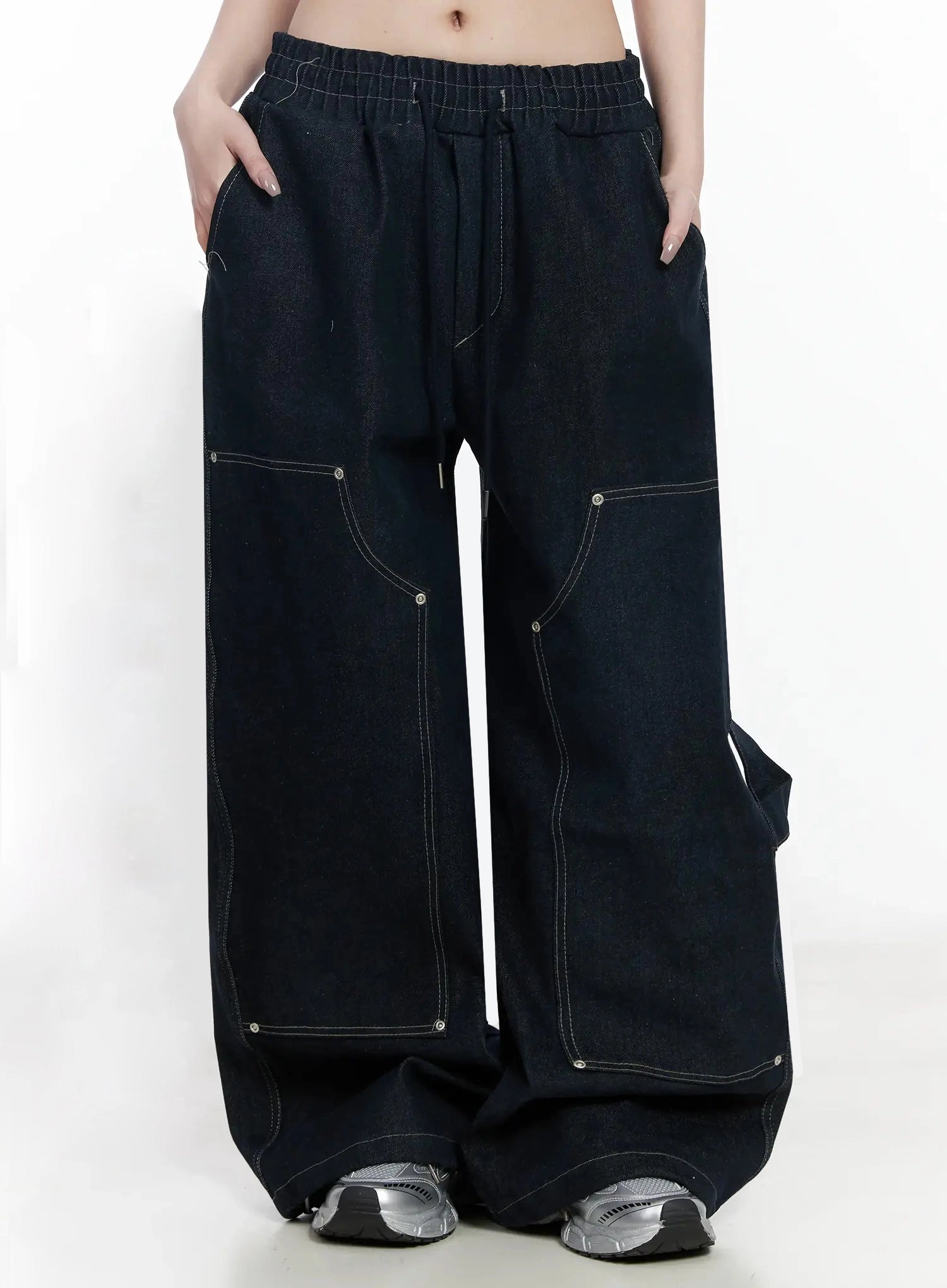 Ashlyn Carpenter Wide-Leg Jeans IJ528 in dark blue, front shot on model with hands in pockets, drawstring elastic waist, multi-panel carpenter stitching and rivet hardware, extra-wide leg.