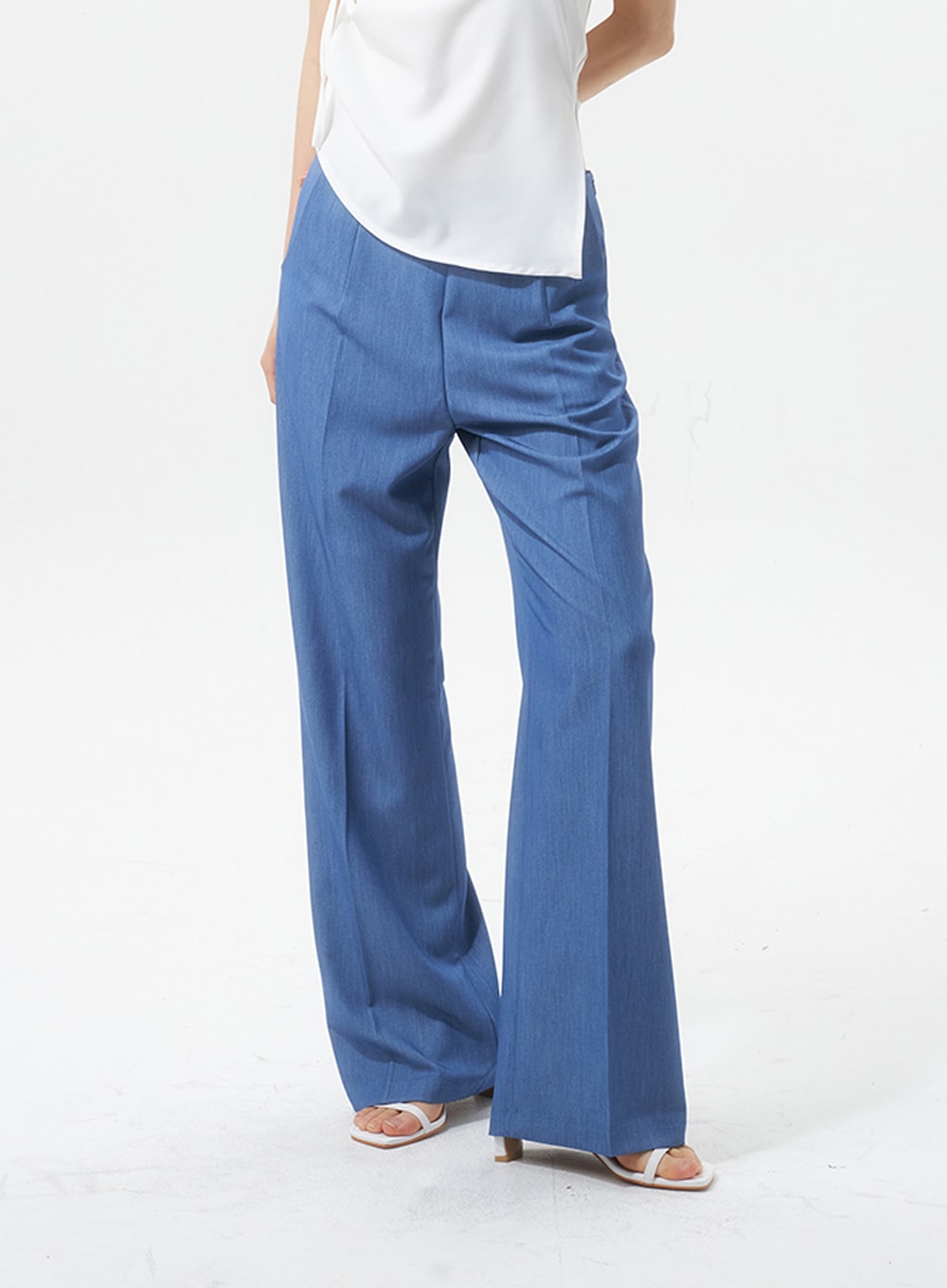 Low Rise Tailored Pants IU326 in blue, side close-up from hip to hem on model, wide-leg silhouette with front and side crease detail visible, paired with white top.